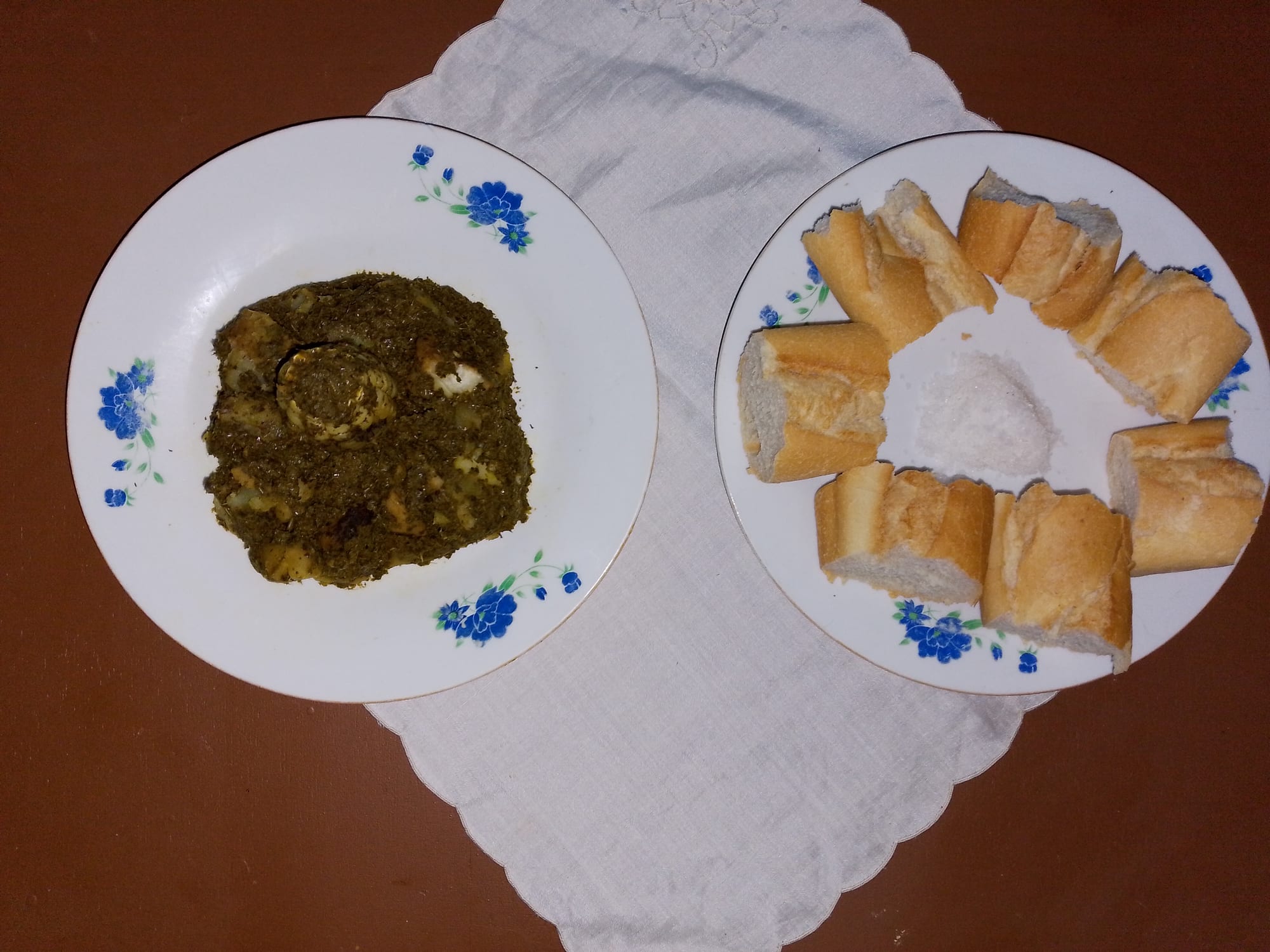 A dark green stew made from pounded leaves in a bowl