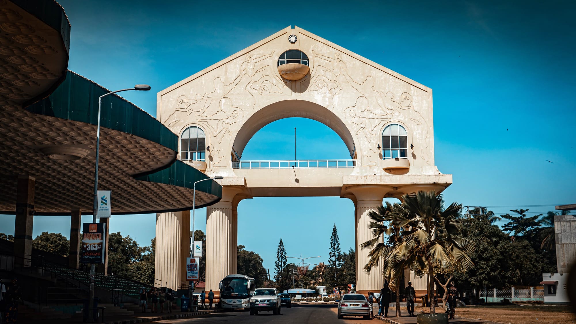 A large ceremonial arch spanning a street, palm trees beside it