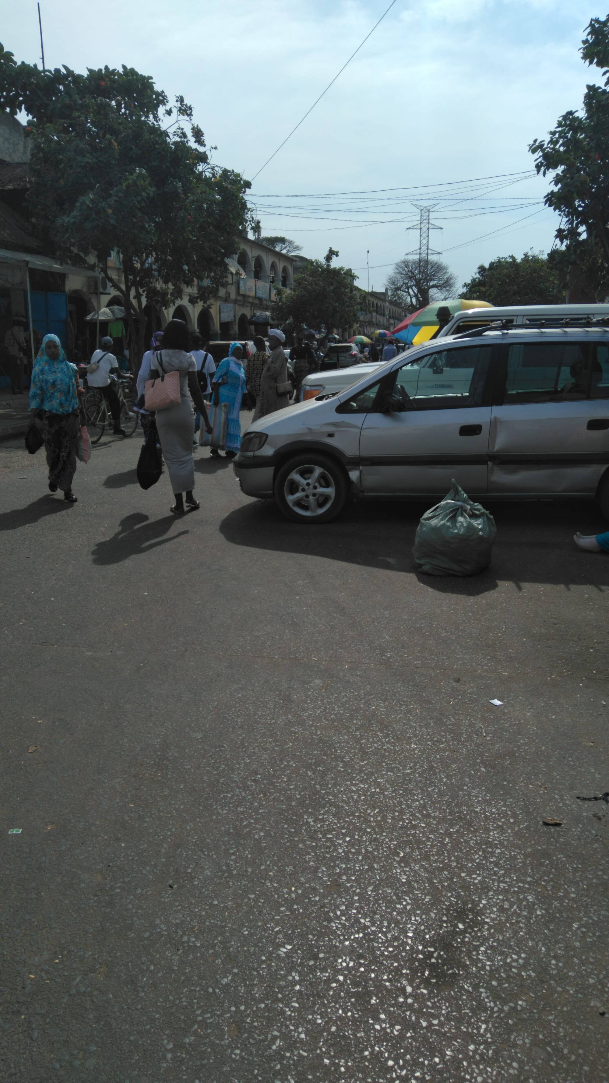 A busy outdoor market street with vendors and stalls