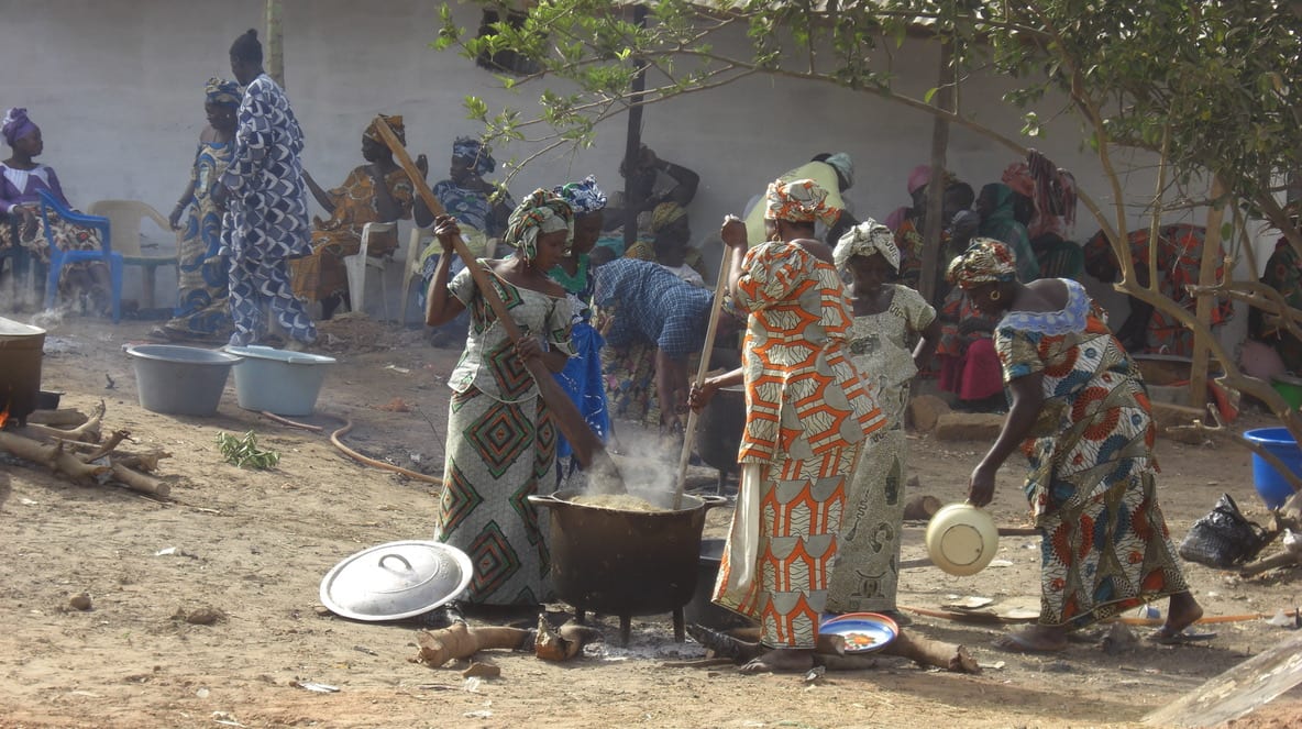 People preparing a stew in large pots outdoors