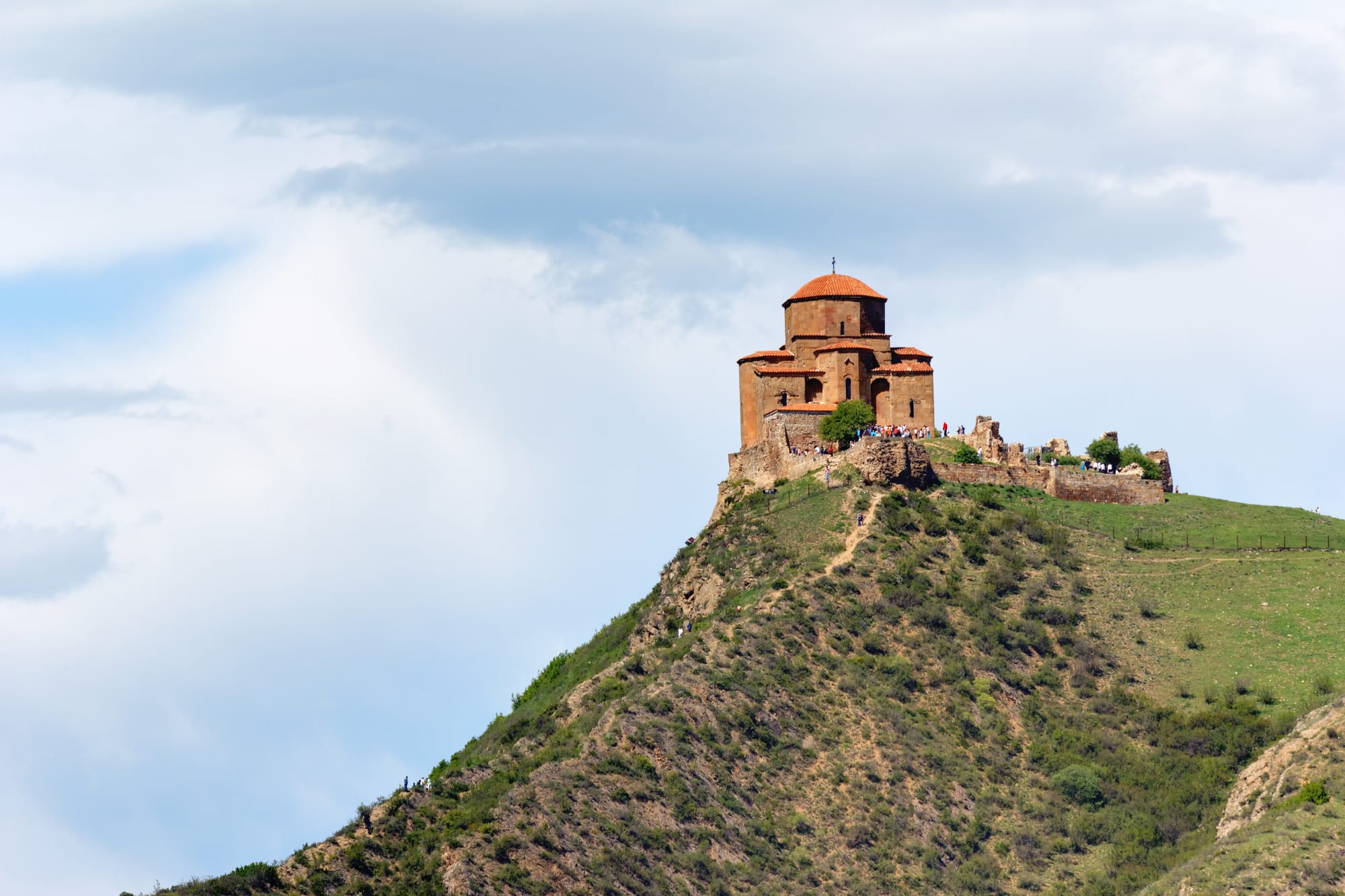 A small stone 6th-century church on a bare hilltop above a river confluence