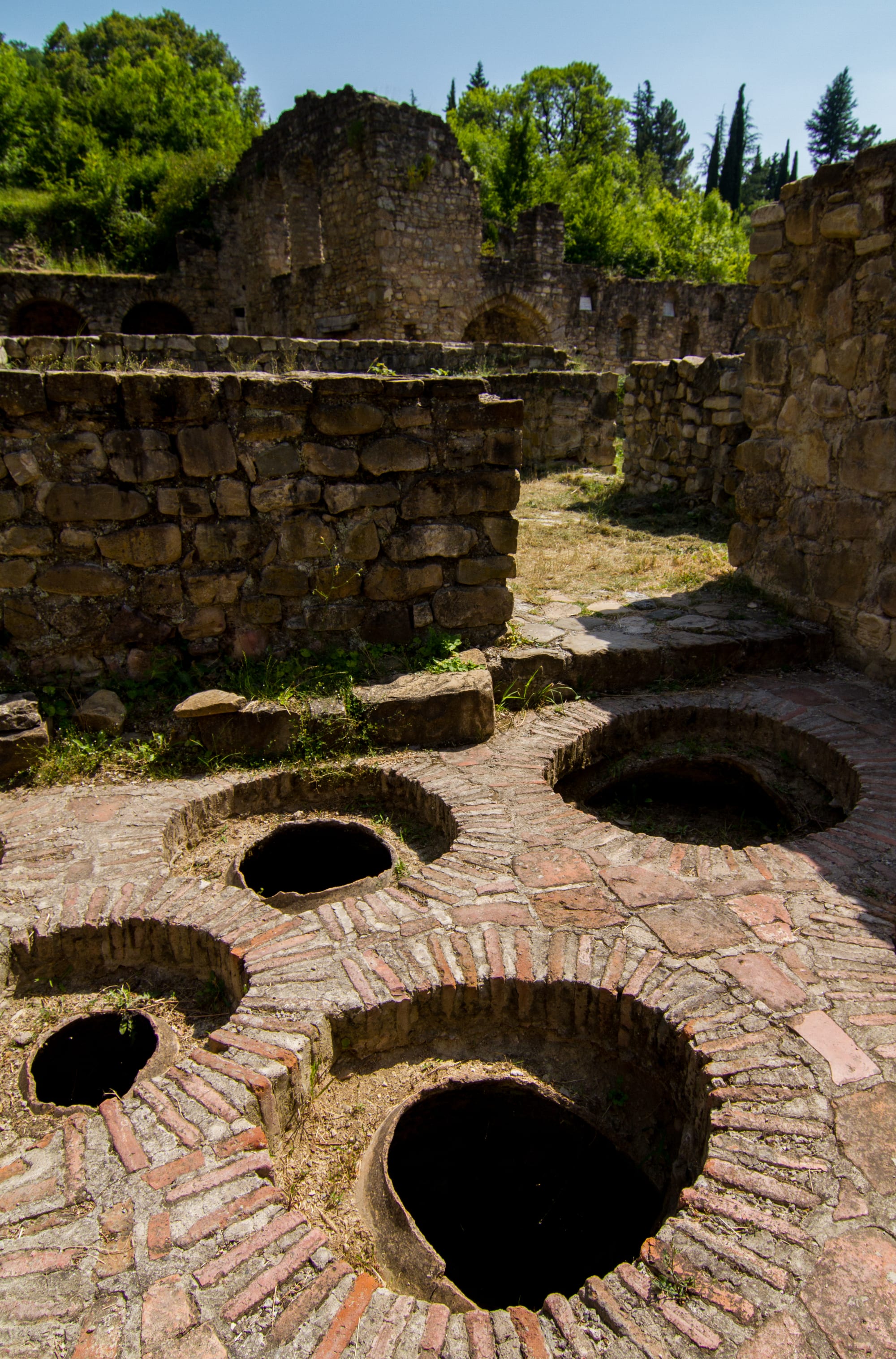 Large round openings of buried earthenware vessels set into the ground