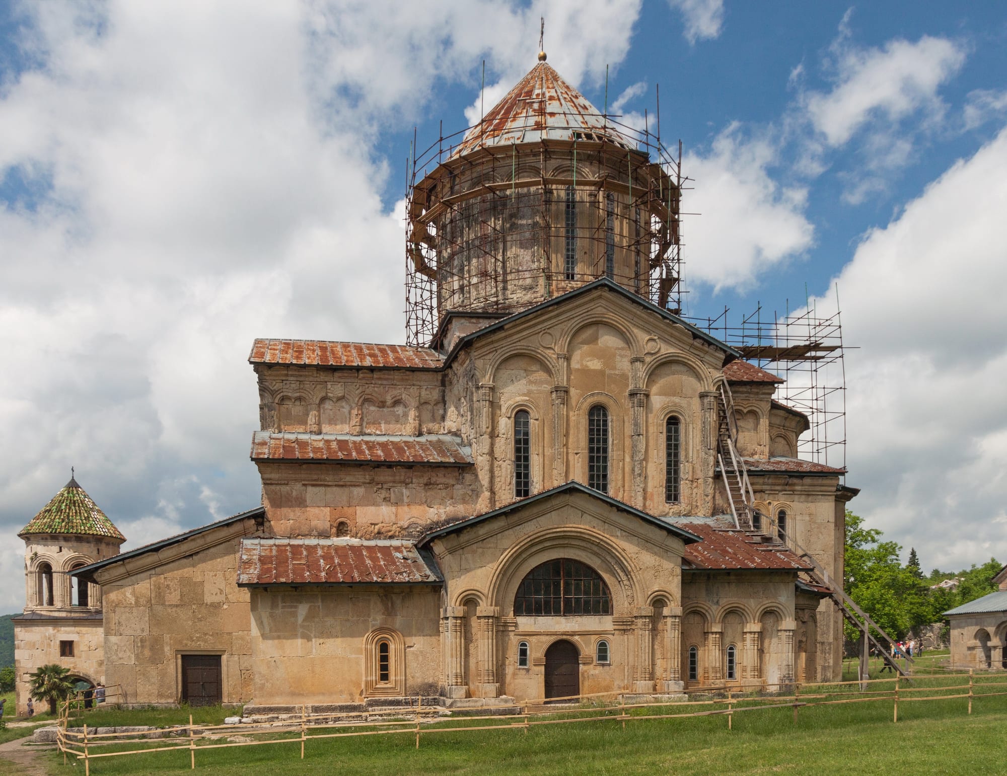 A domed medieval monastery complex of pale stone on a green hillside