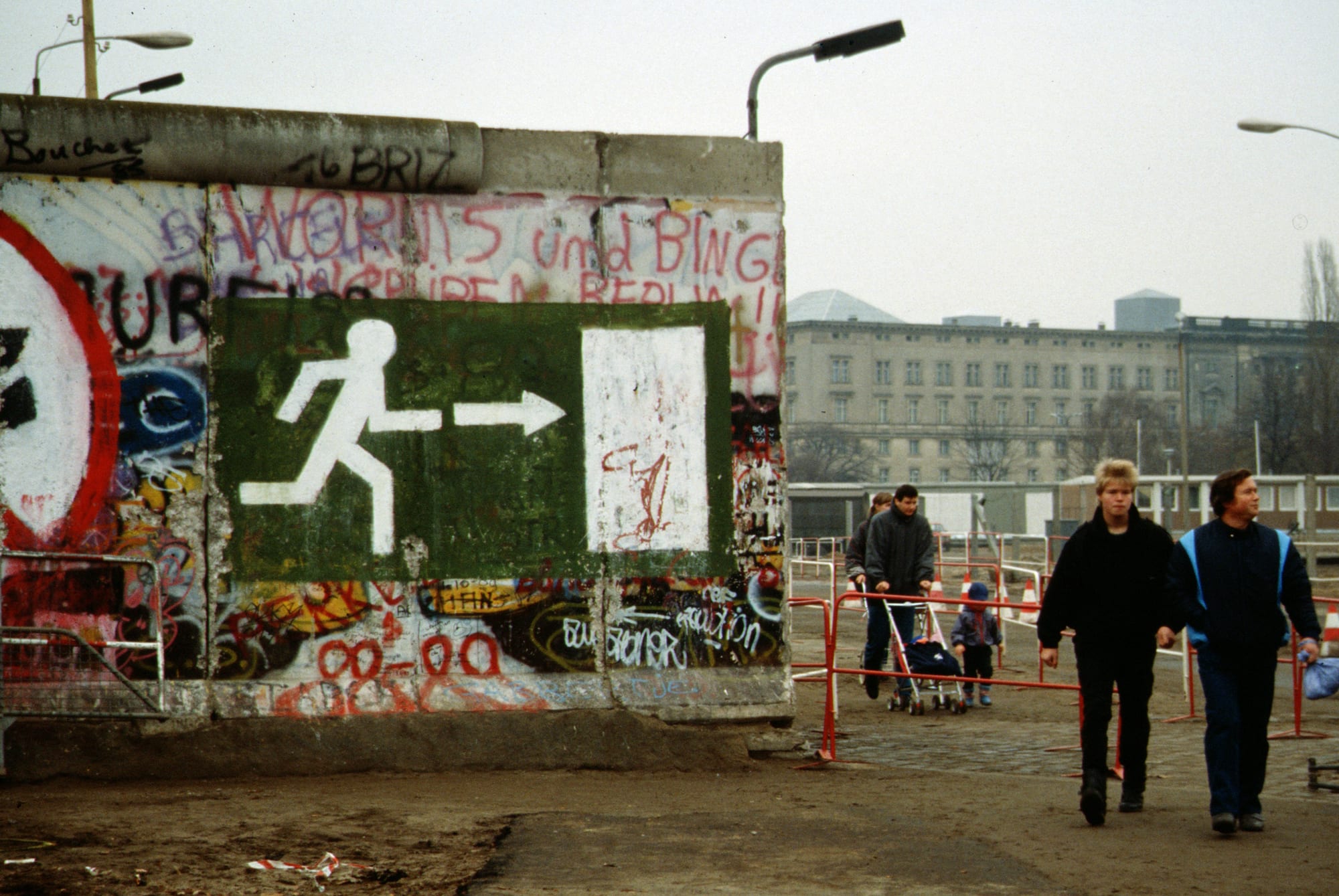 Crowds of people streaming through an opening in the Berlin Wall in 1989