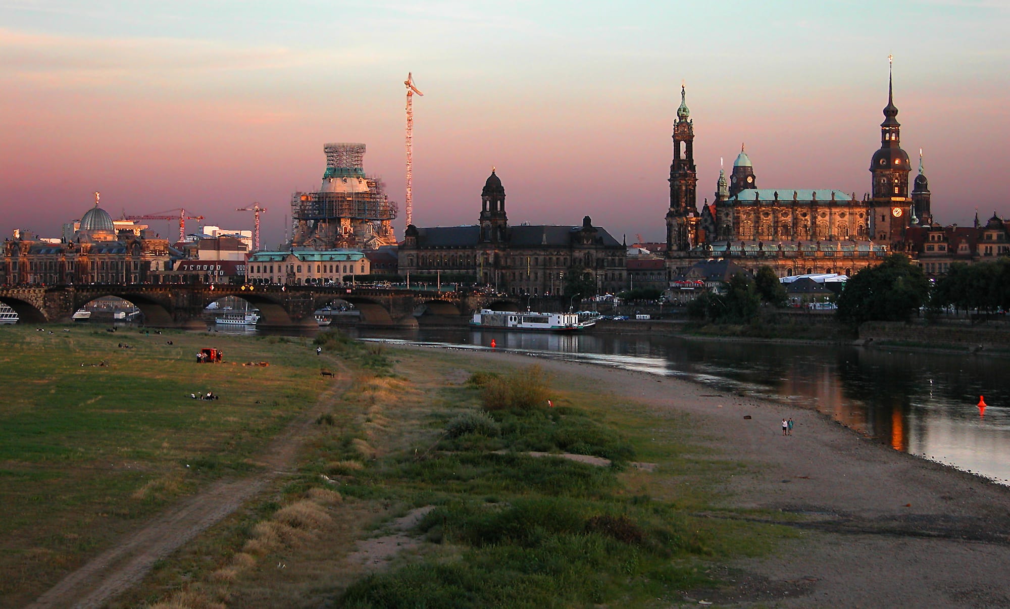 A baroque domed church and cathedral rising above a riverside terrace