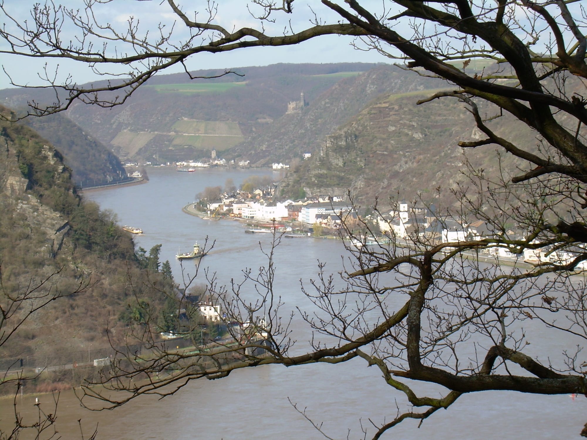 A curving river far below, hemmed by steep vineyard slopes and a small town
