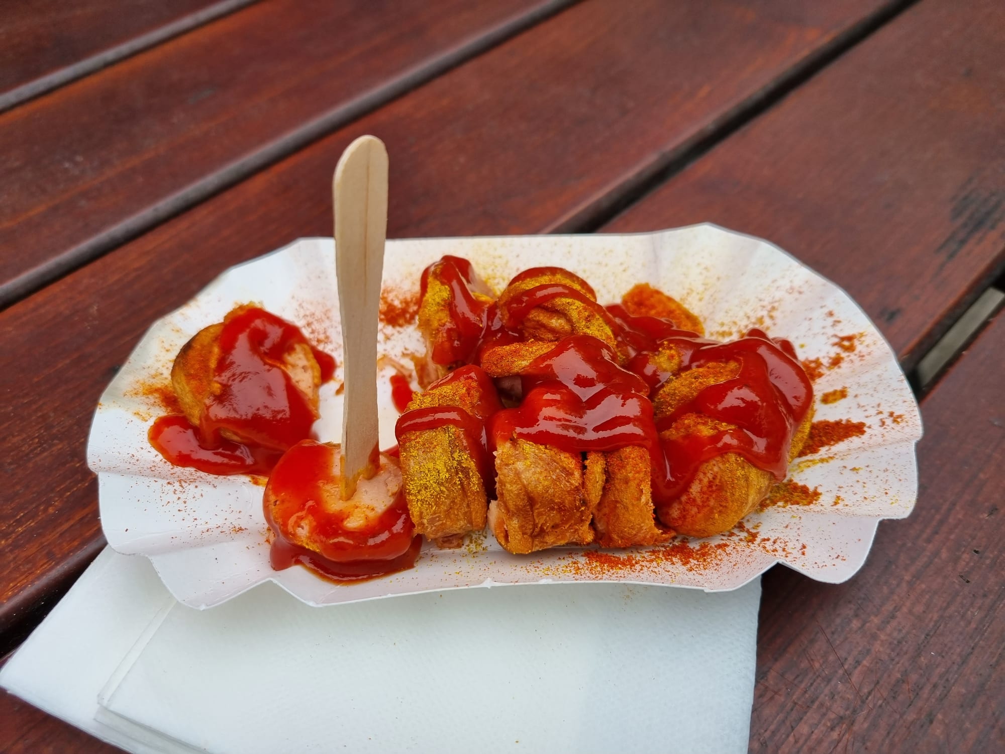 Sliced sausage topped with curry-spiced ketchup and served with fries