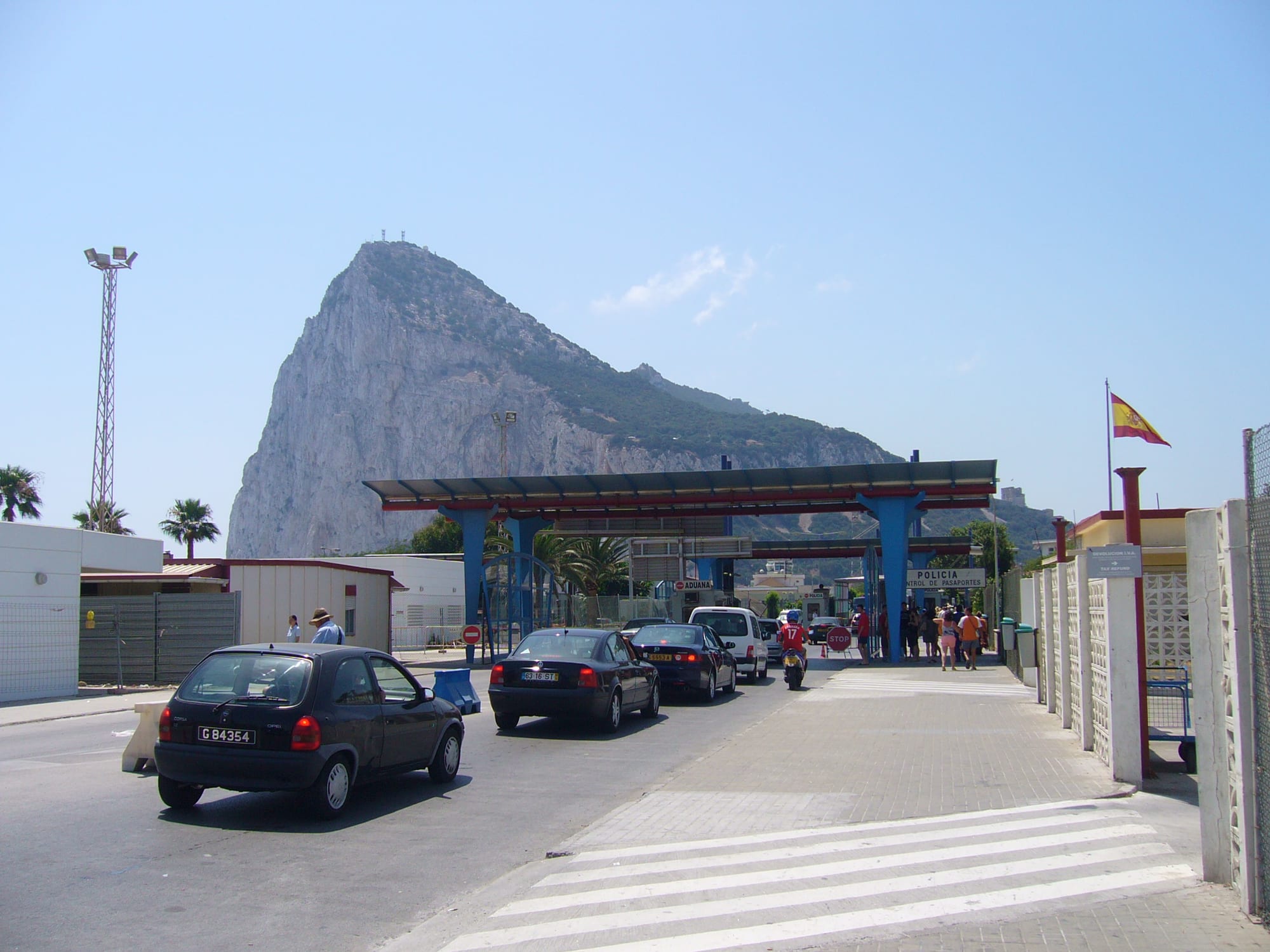 The sheer north face of a limestone rock towering over a town at its foot