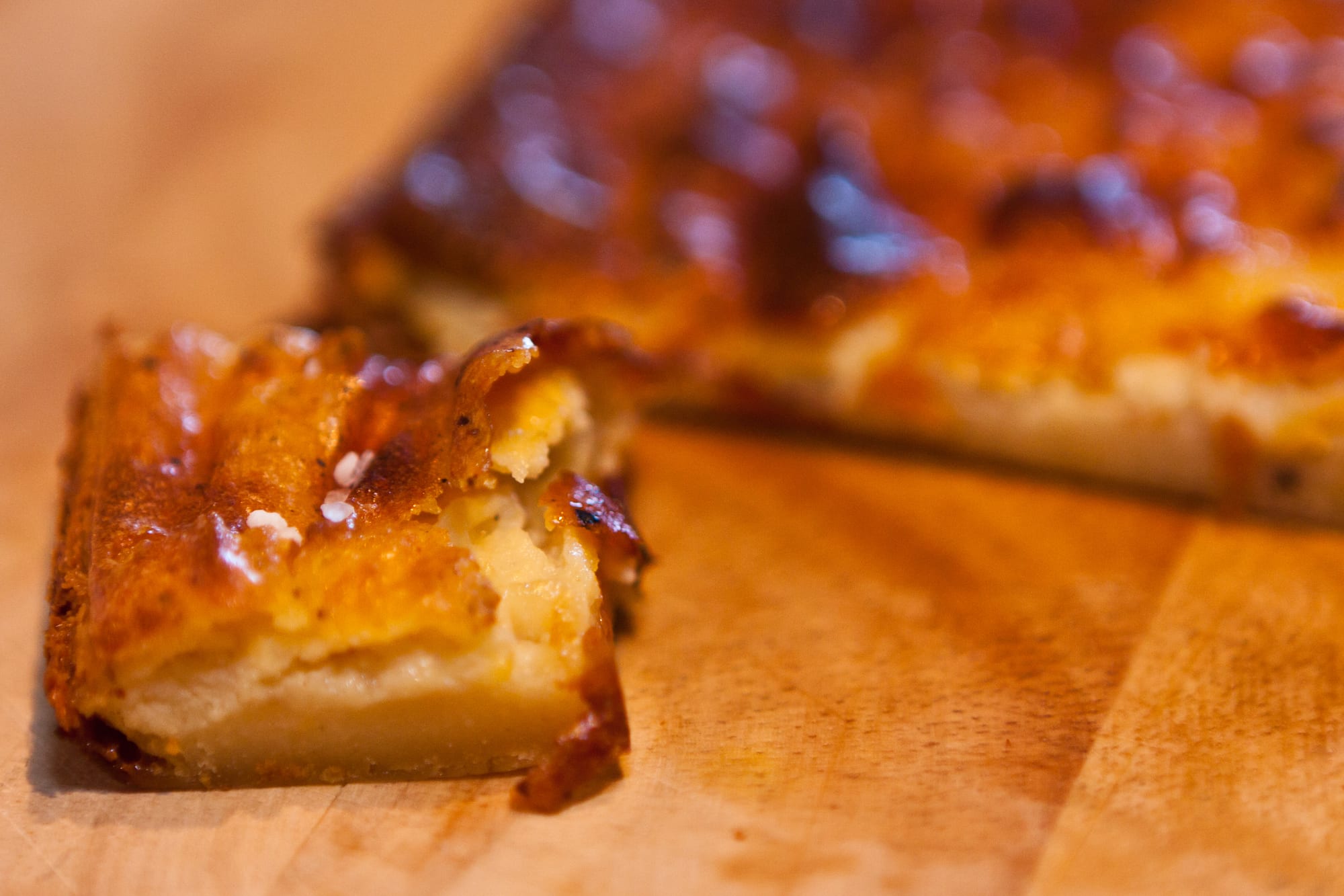 A tray of dense, golden baked cake cut into squares
