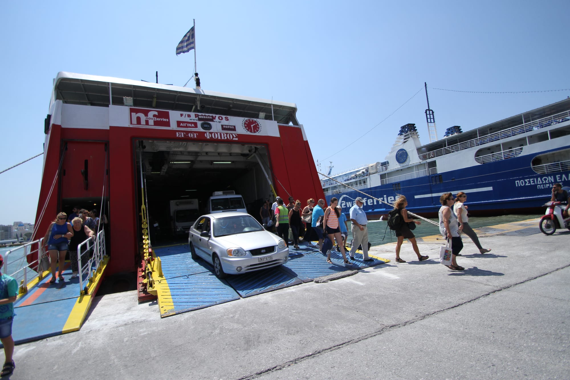 Passengers and a car disembarking a car ferry at the port of Piraeus, with another ferry docked alongside