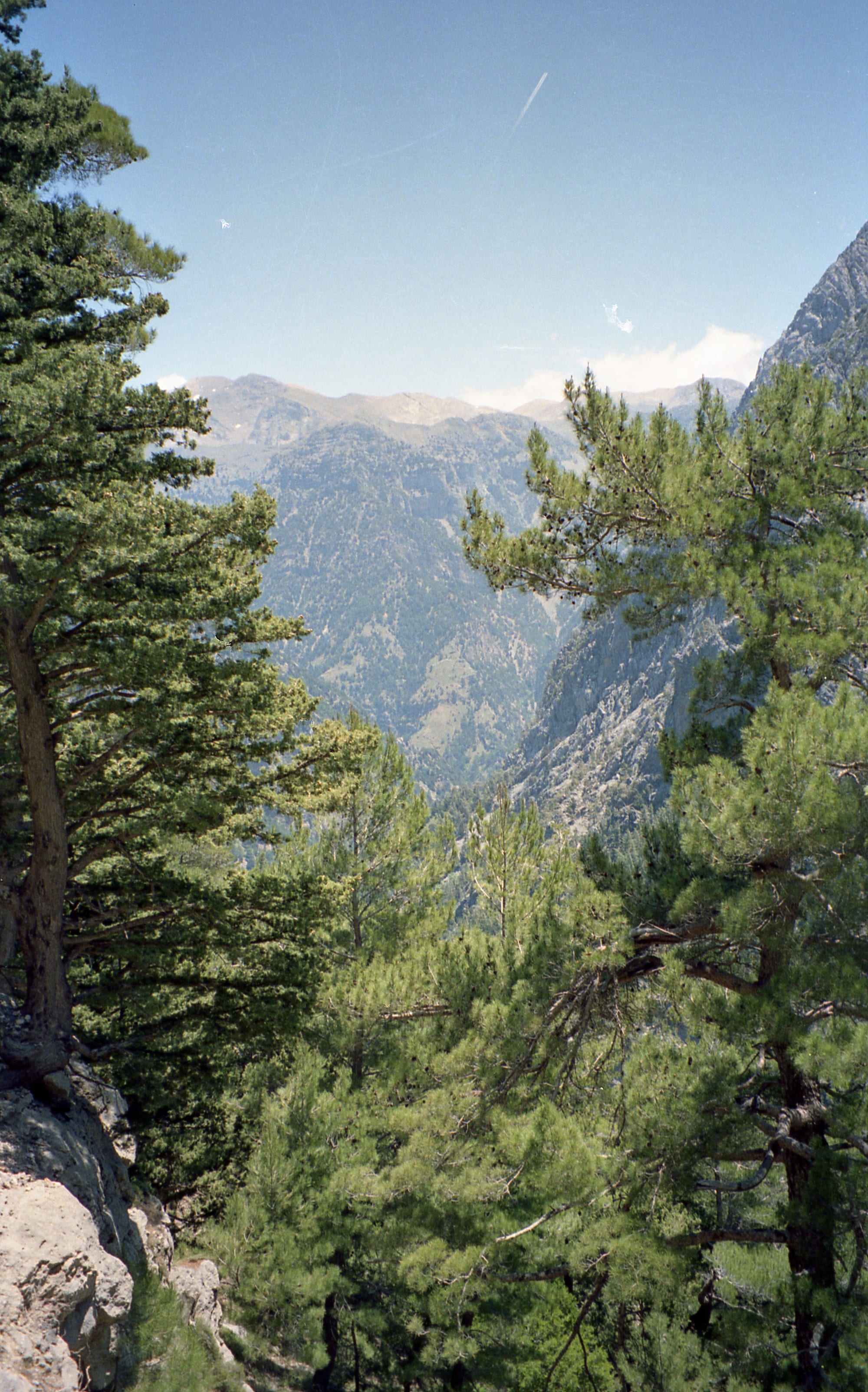 A hiking path along a dry river bed between towering rock walls