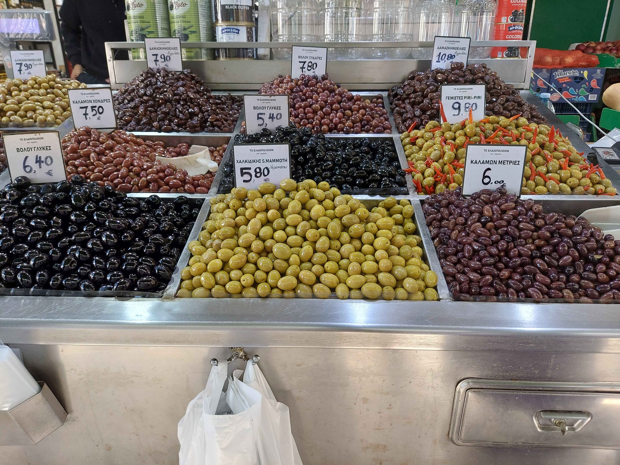 A market stall with many bowls of different olive varieties