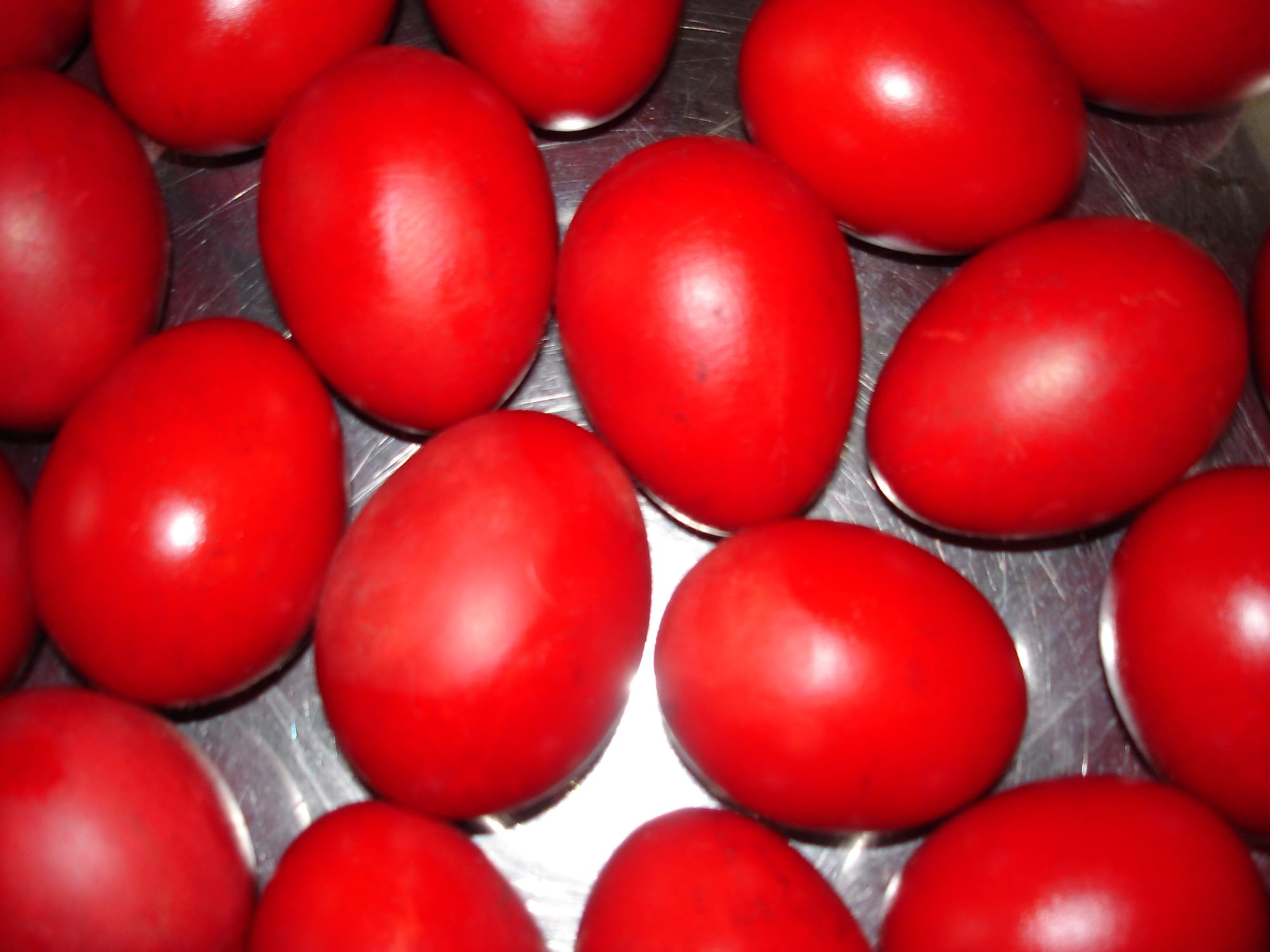 A tray of shiny eggs dyed a deep, even red