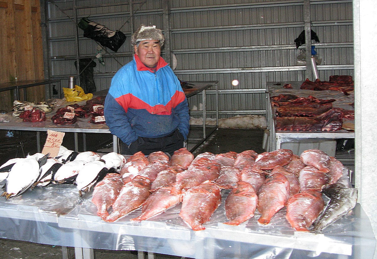 A market stall with fish and game meat laid out for sale