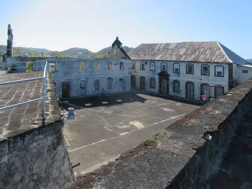 Old stone fort walls and cannon on a headland above a harbour and town