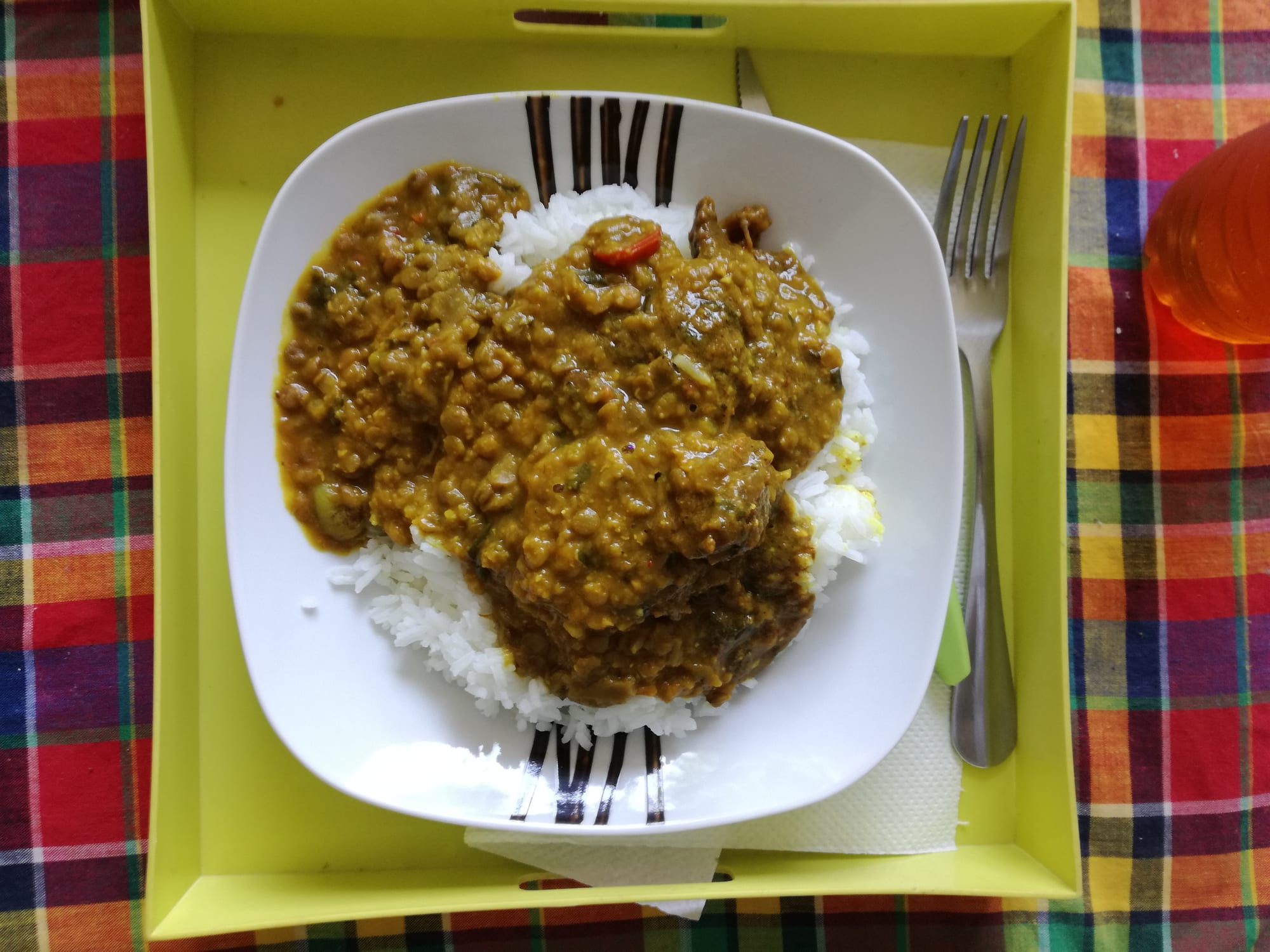 A yellow-spiced stew with meat and vegetables in a bowl