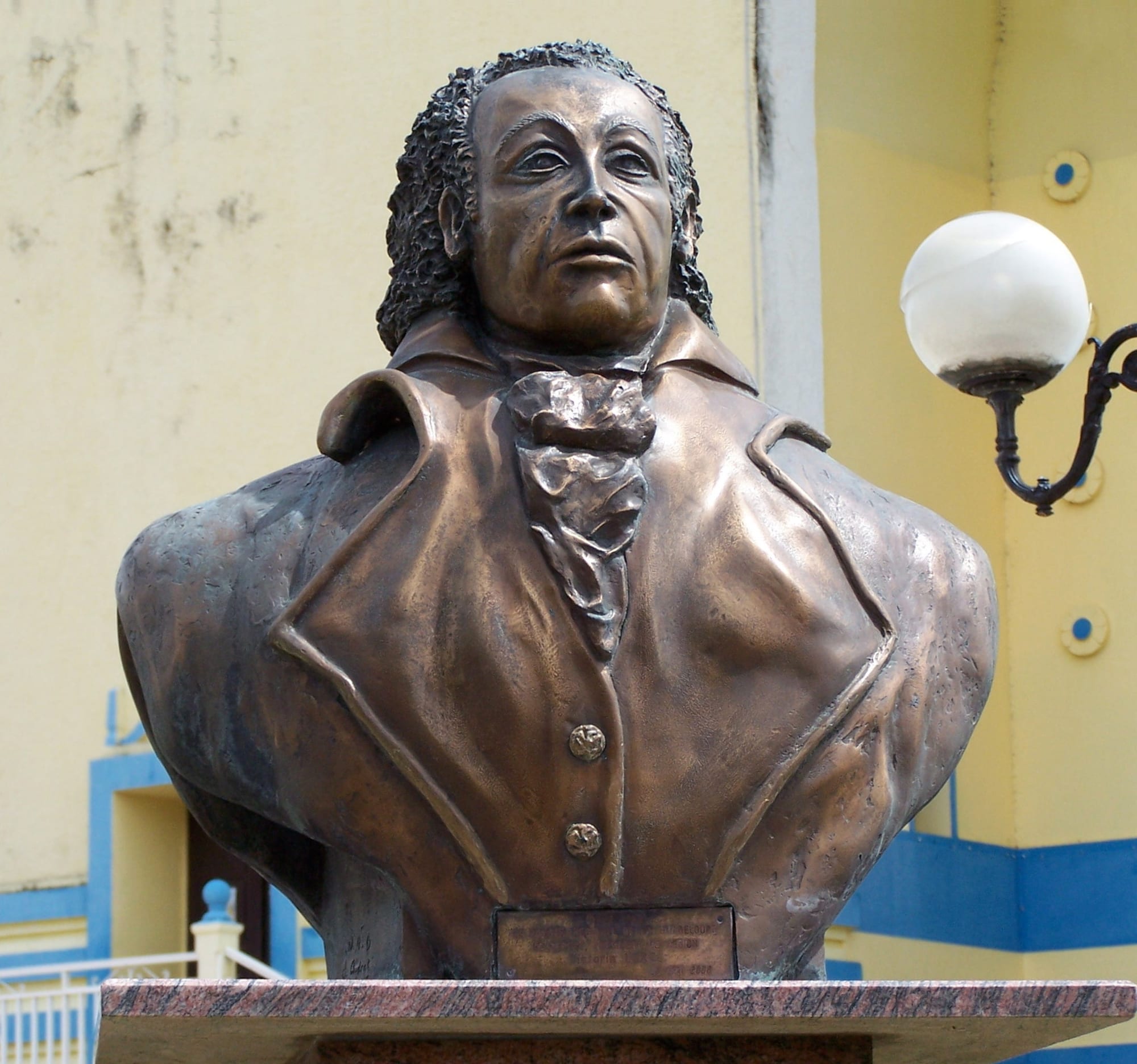 A bronze bust of Louis Delgrès on a stone pedestal