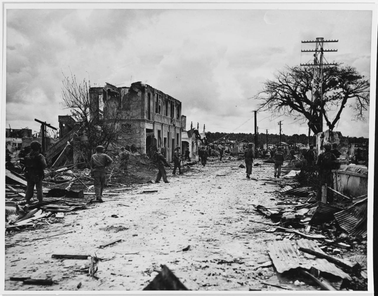 Marines walking through the rubble of destroyed buildings in Hagåtña, 1944
