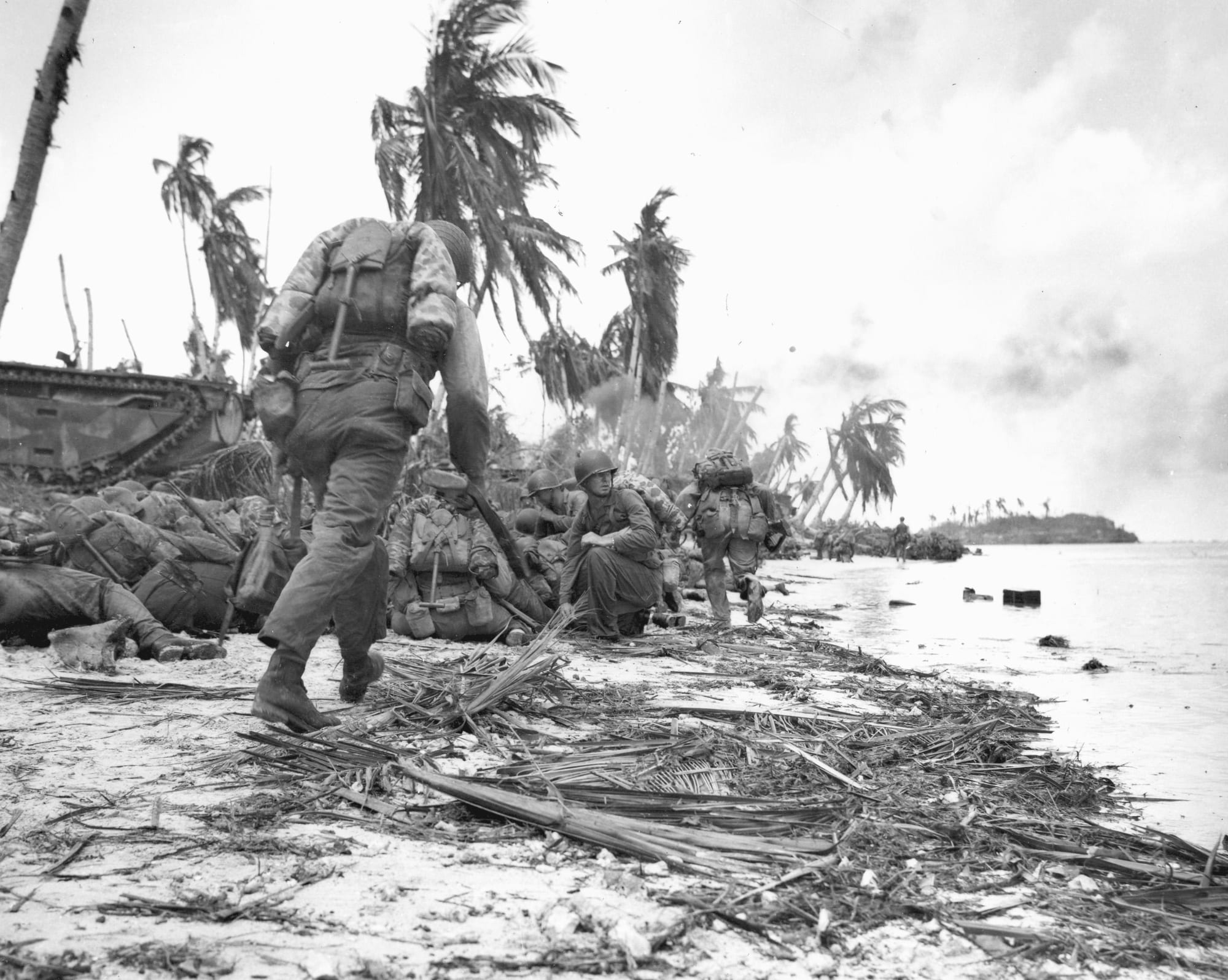 US Marines wading ashore and advancing up a beach under fire on Guam, July 1944