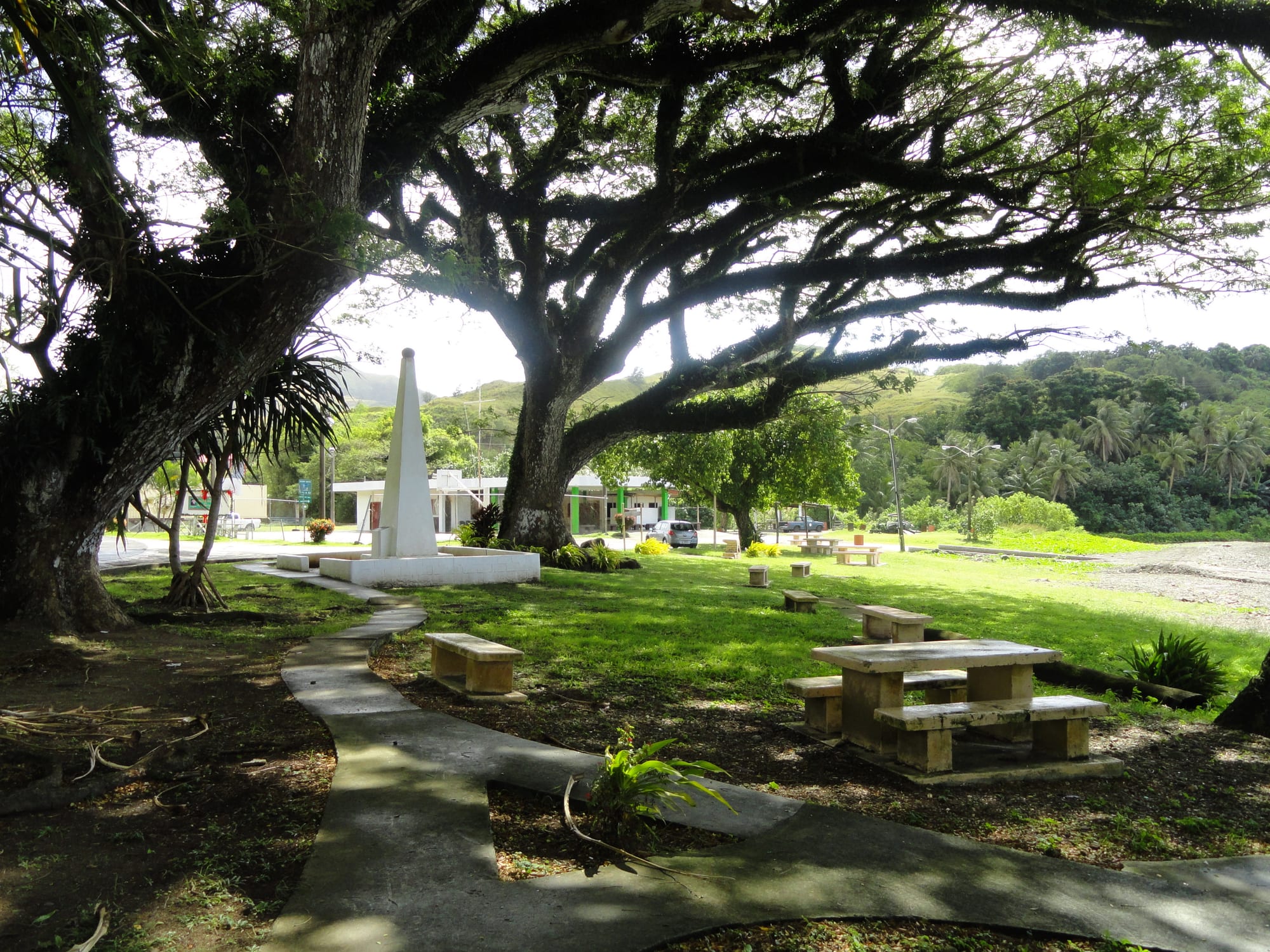 A white obelisk monument to Magellan on a lawn near the sea at Umatac