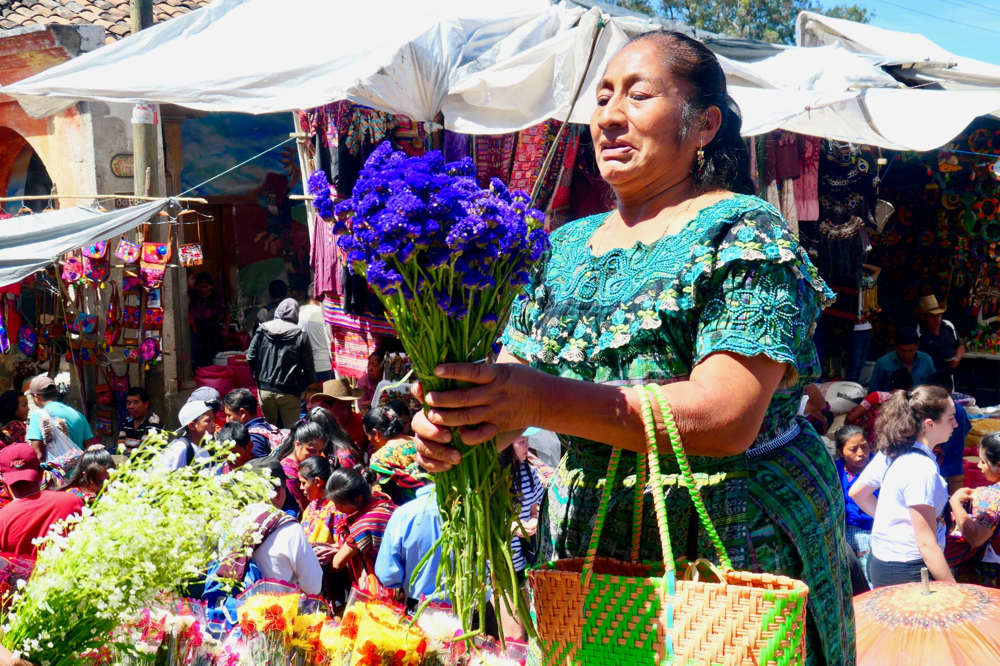 A dense market of stalls under coloured tarpaulins packed into narrow streets