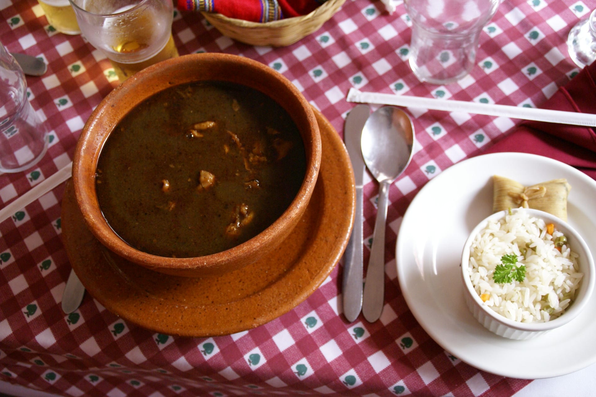 A bowl of spiced soup with meat, served at a restaurant table