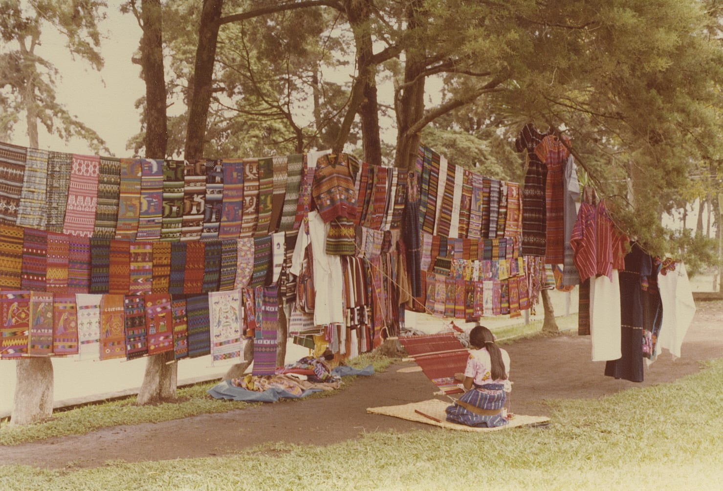 Brightly patterned handwoven textiles hanging at a Guatemalan highland market