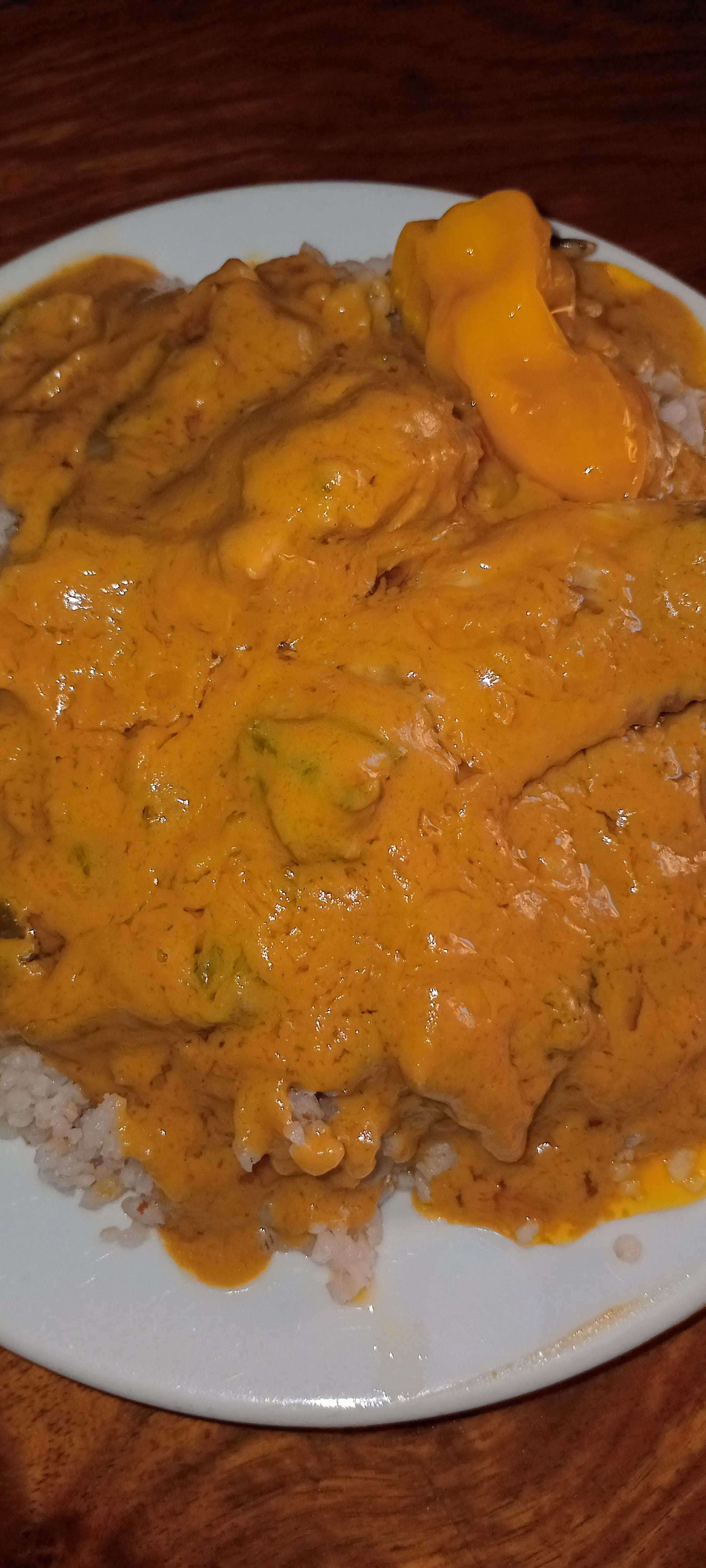 A bowl of thick, reddish-brown peanut stew with rice