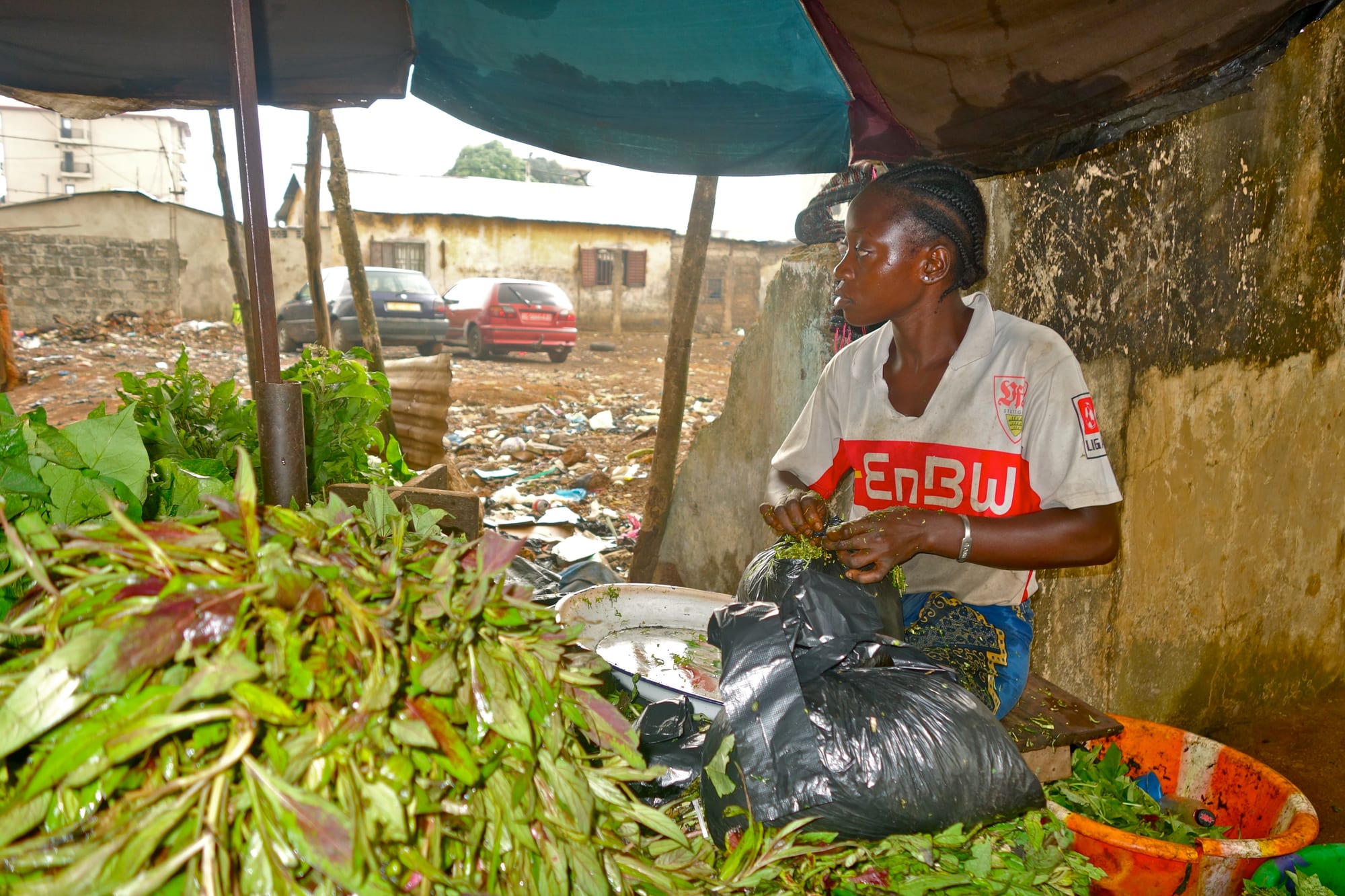 A woman selling cassava at an outdoor market stall