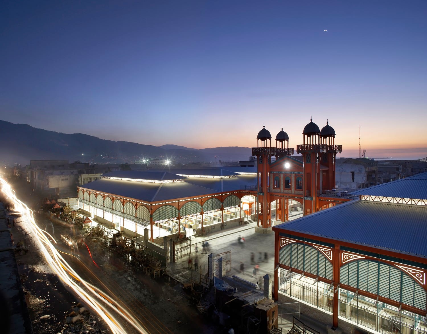 A red-and-green iron market hall with clock towers and minaret-like spires