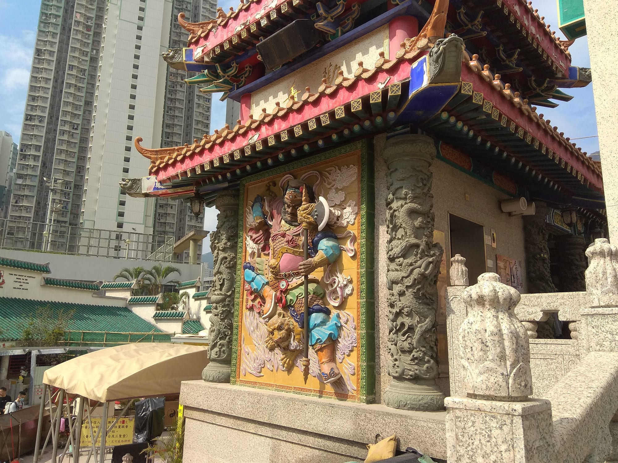 A colourful Taoist temple with red pillars and a golden roof, thick with incense smoke