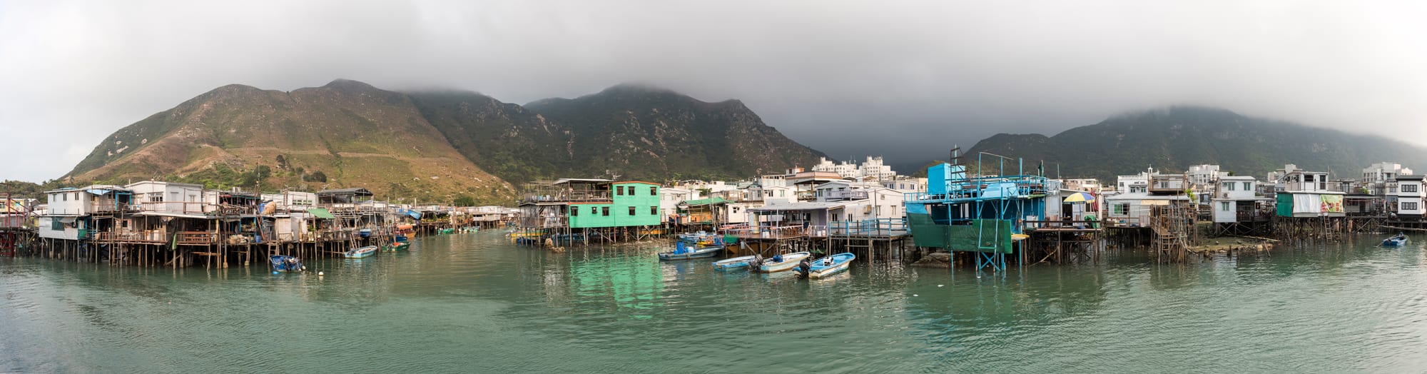 Weathered houses on stilts crowded along tidal creeks in a coastal village
