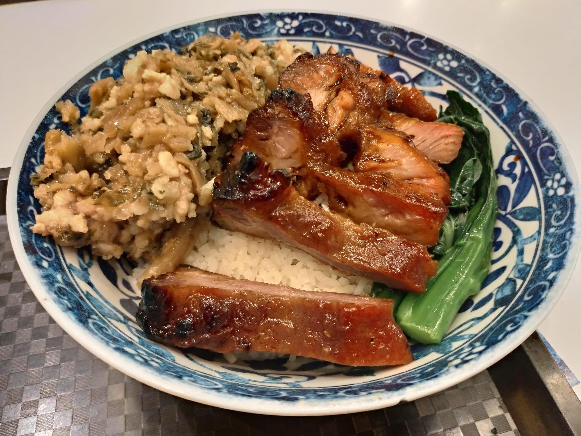 A bowl of rice topped with sliced barbecue pork and minced pork