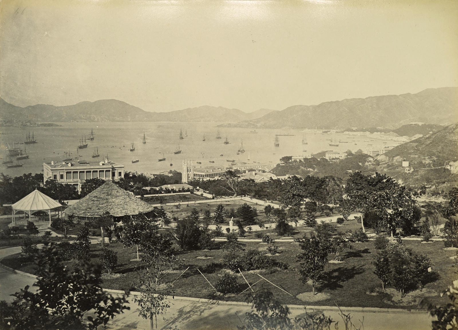 An 1870s photograph of Victoria Harbour with sailing ships and low colonial buildings along the shore