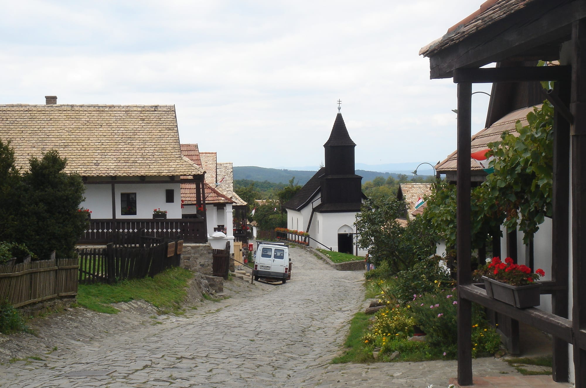 A lane of whitewashed cottages with wooden porches and a small wooden church