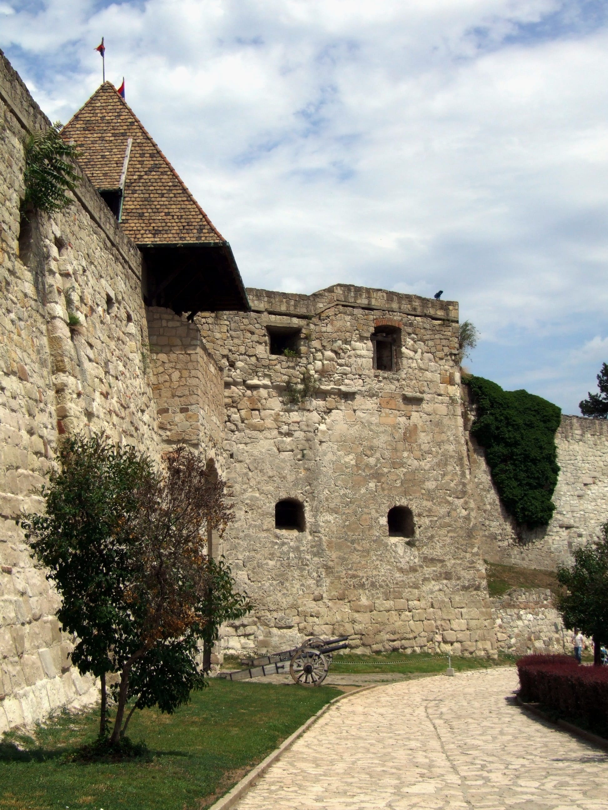 A stone hilltop castle and bastions overlooking a baroque town of church spires