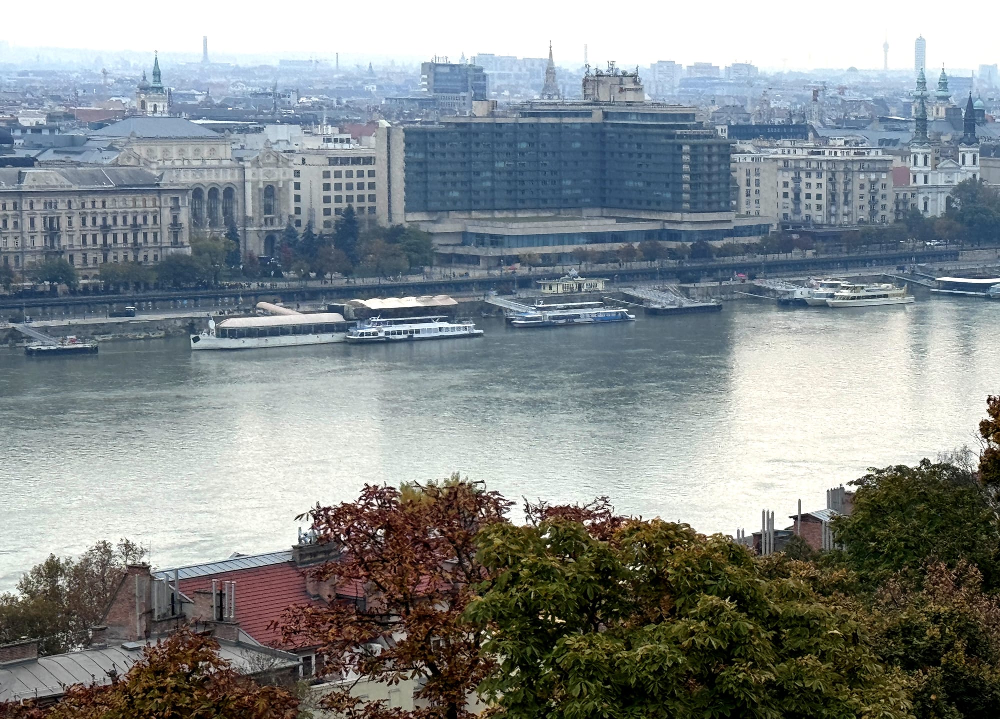 A wide river with grand 19th-century buildings and a domed parliament along the far bank