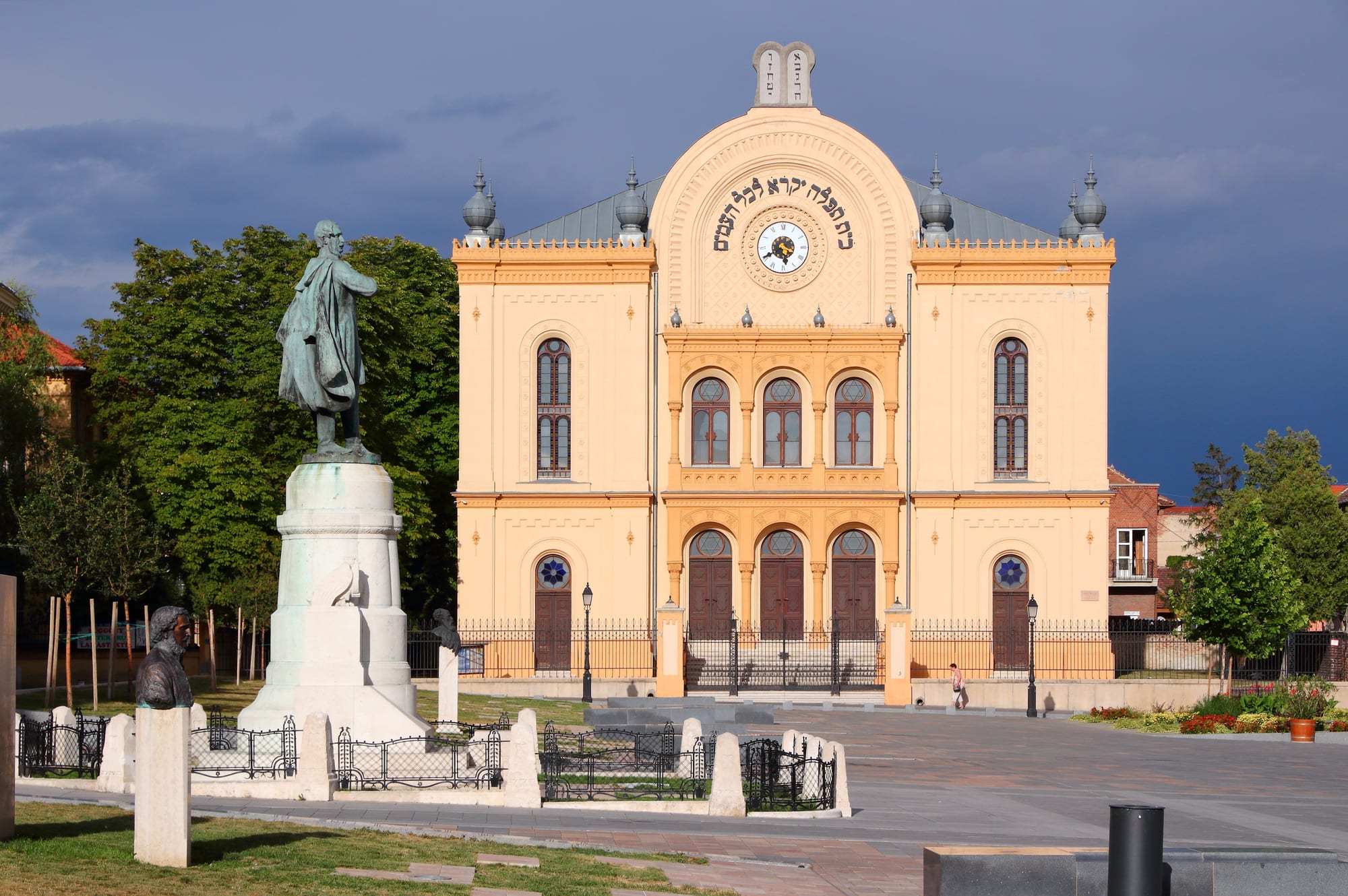 A large Romantic-style brick synagogue with twin towers on a town square