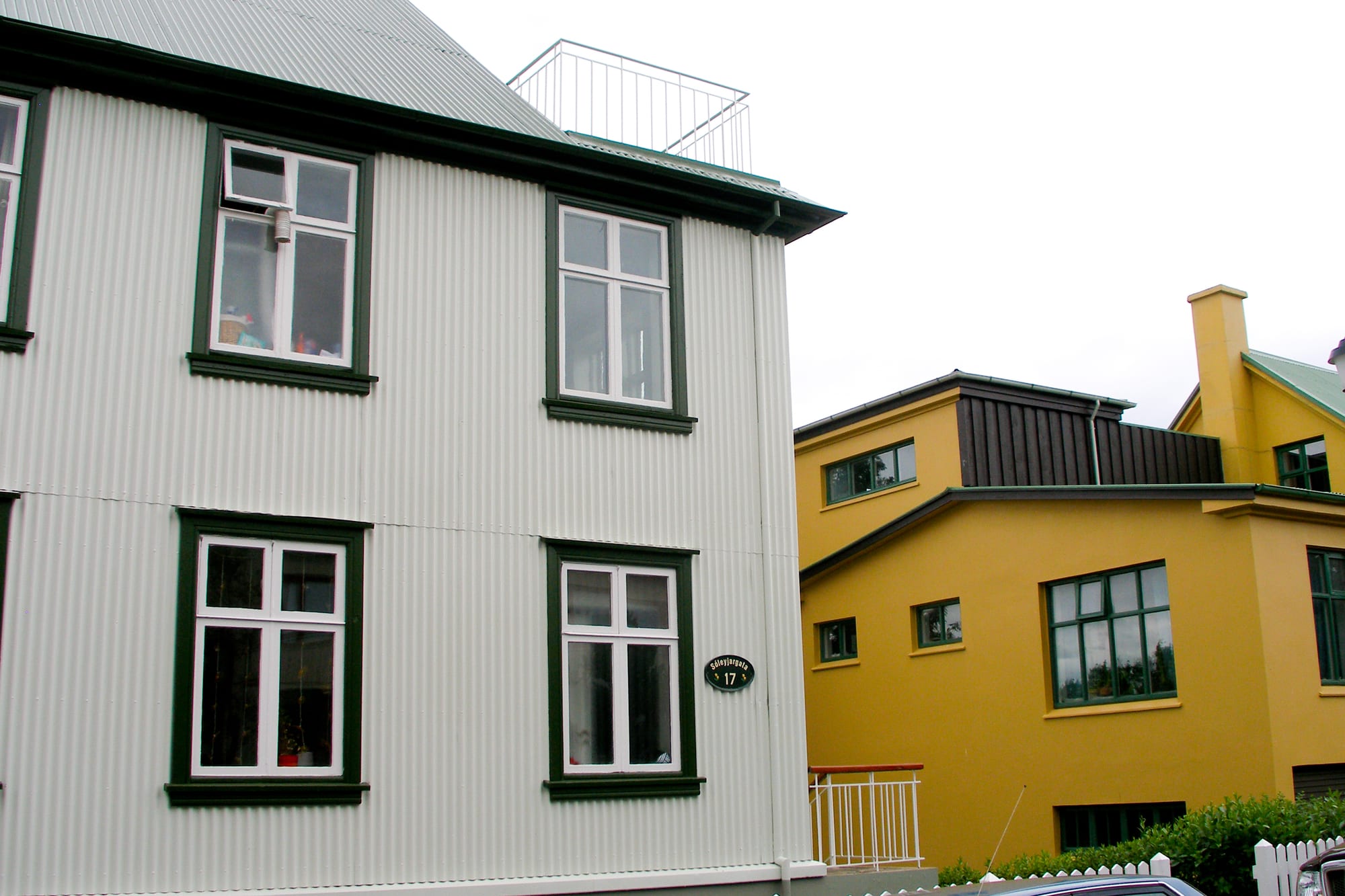 Corrugated-iron-clad houses in white and mustard yellow on a Reykjavík street