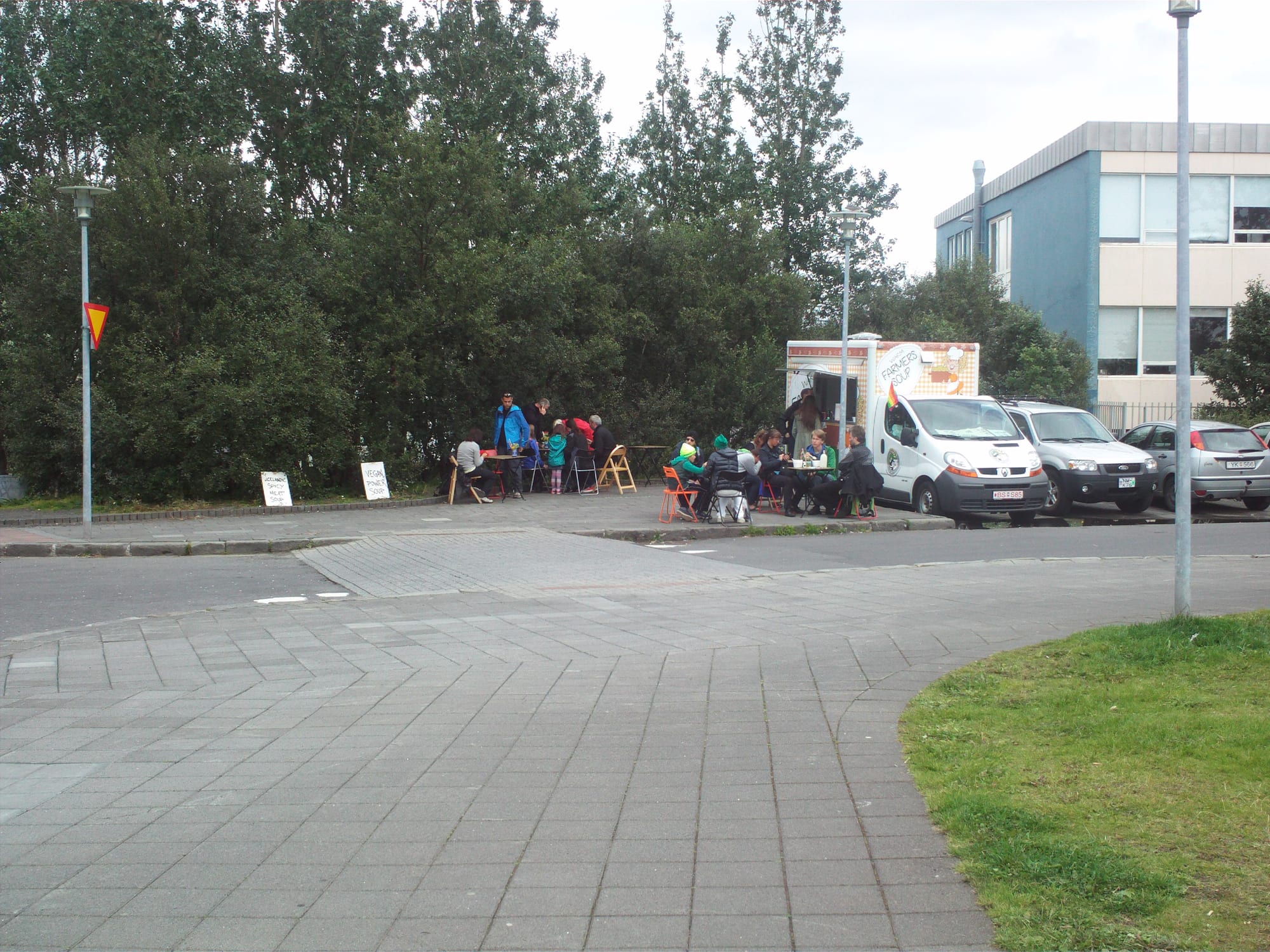 A street food stand serving bowls of soup outside a church