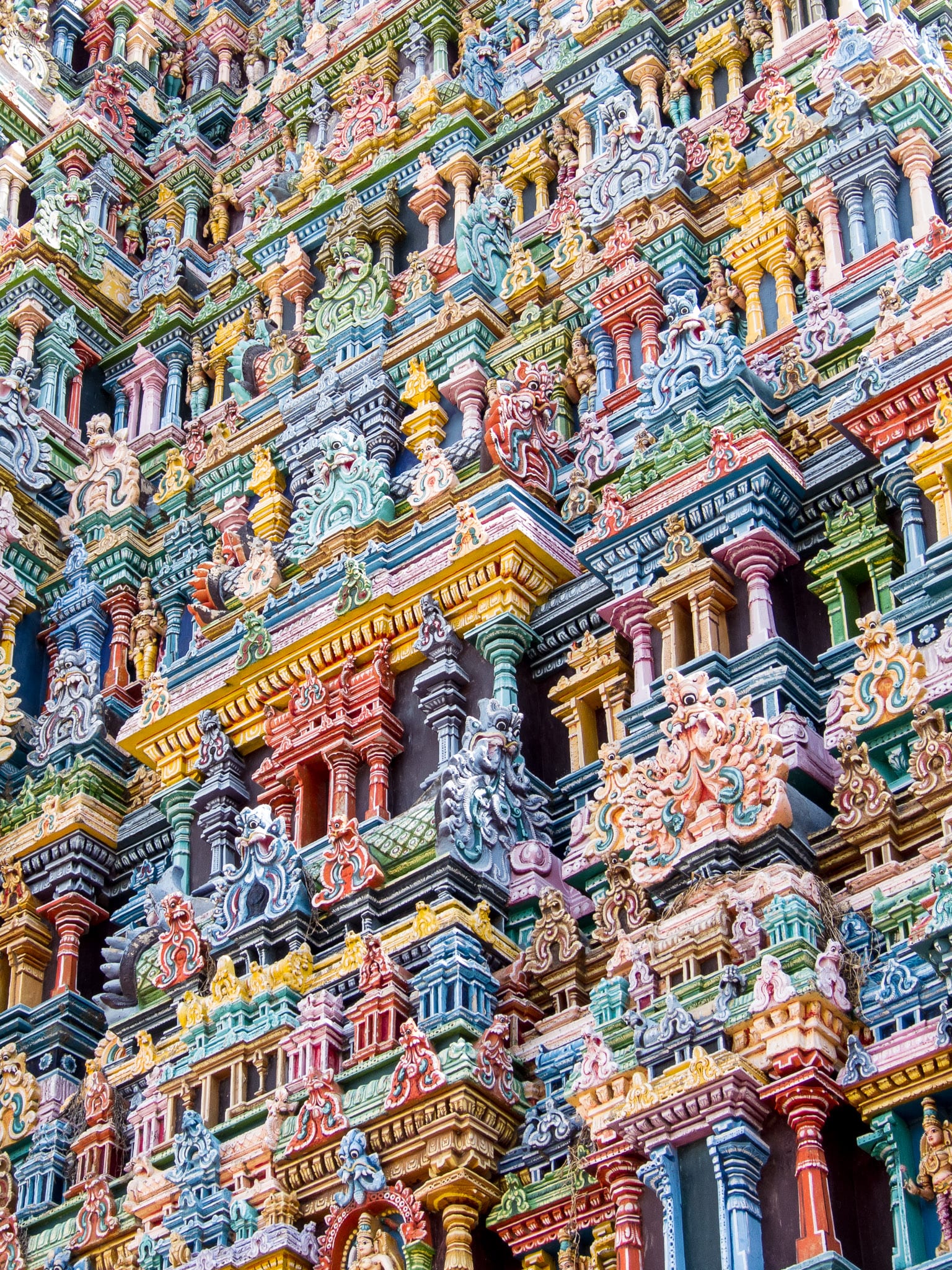 A towering temple gateway covered top to bottom in thousands of brightly painted figures
