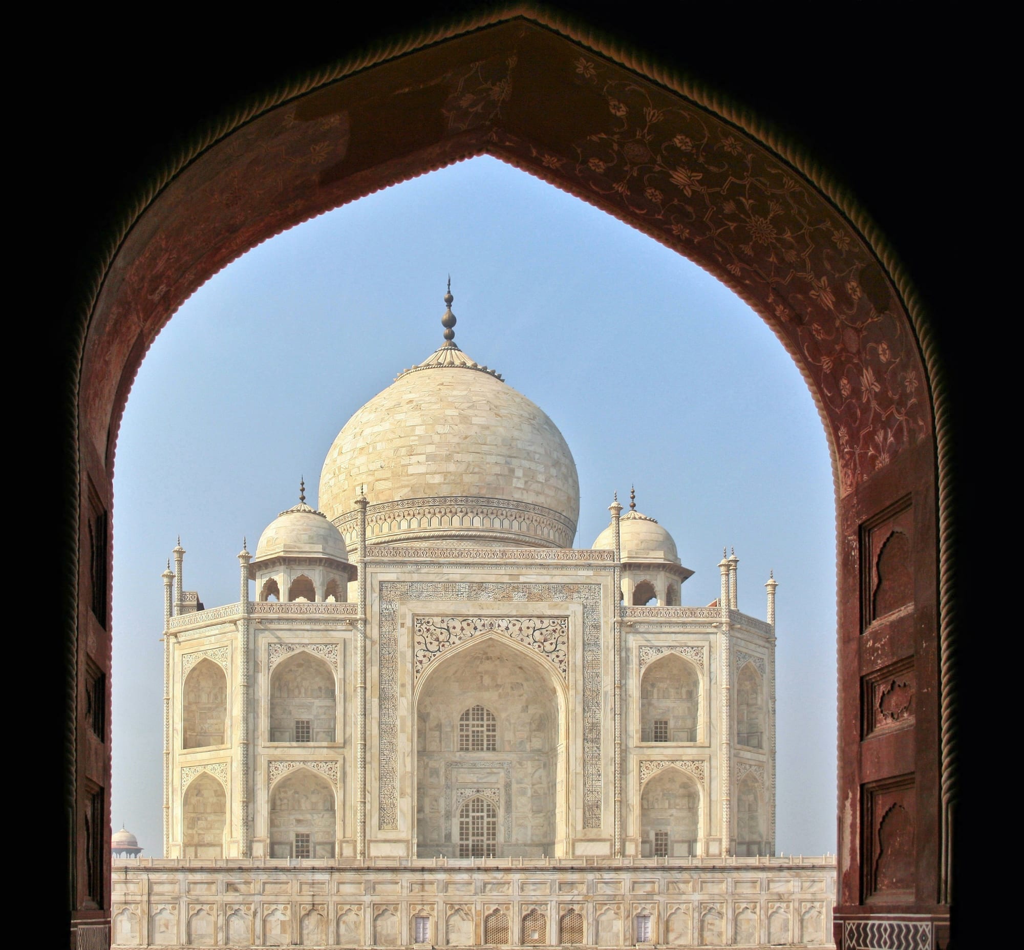 The Taj Mahal seen at an angle from the gardens, its marble glowing in warm light