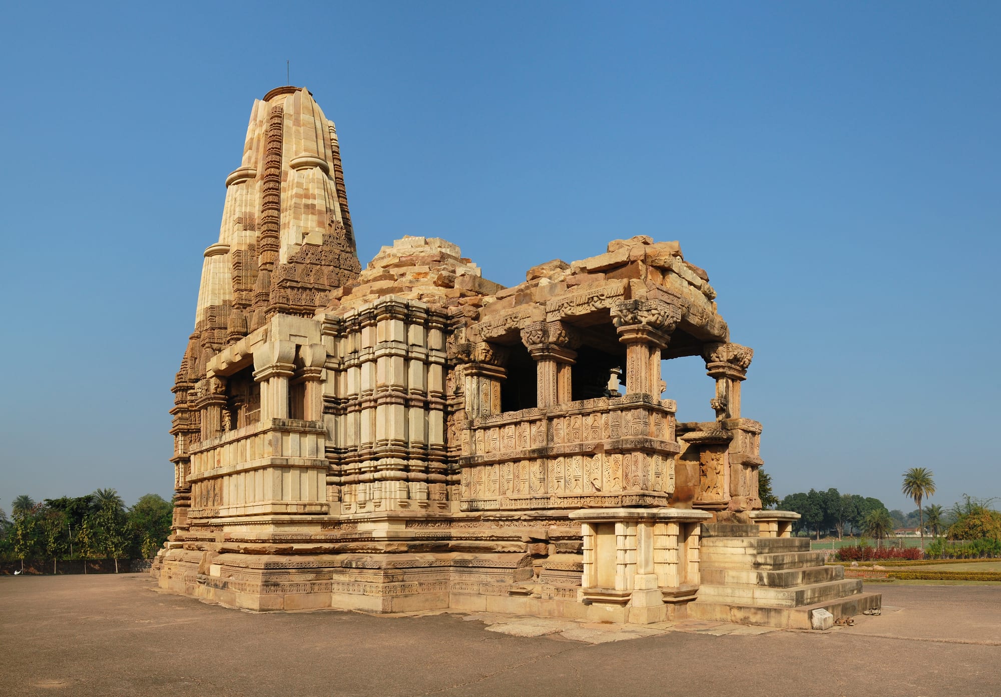 A tall, richly carved stone temple tower covered in tiers of sculpted figures