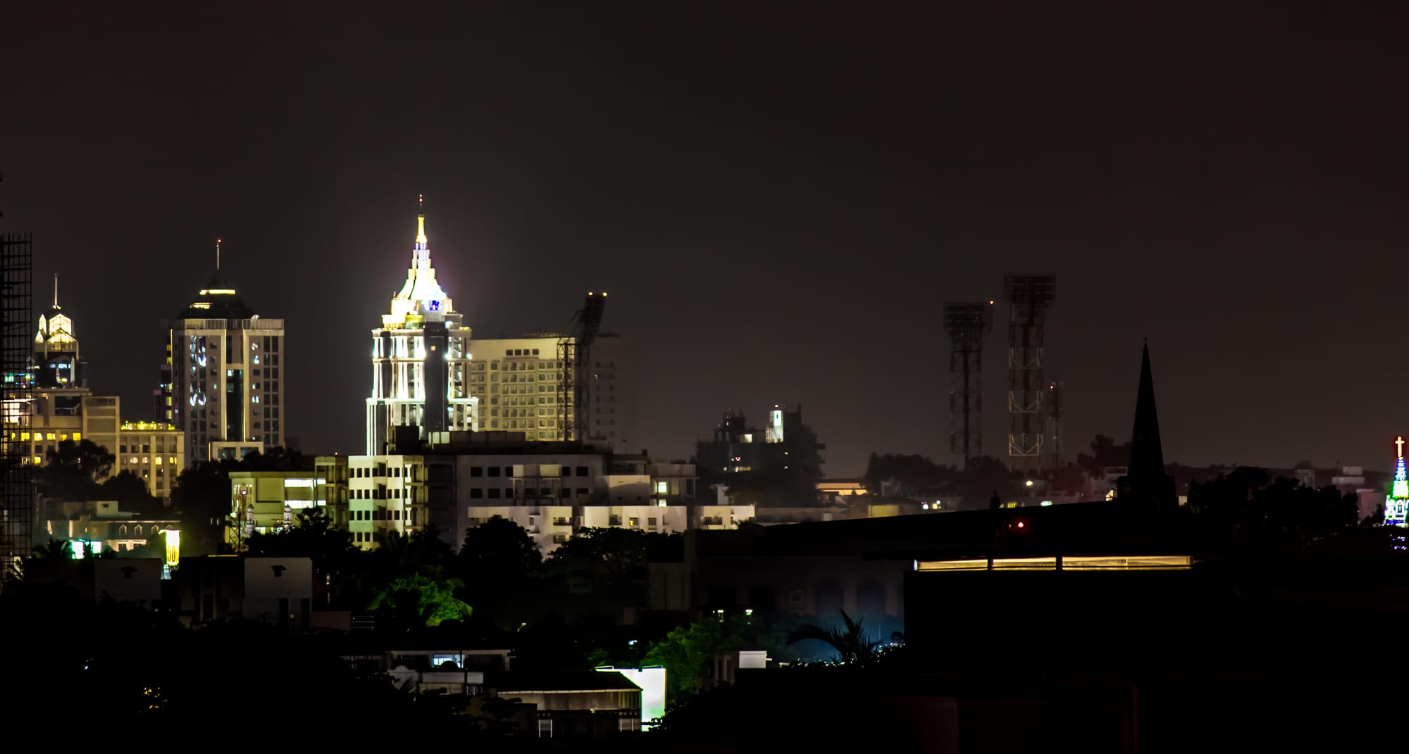 A skyline of glass office towers in Bangalore against a hazy sky