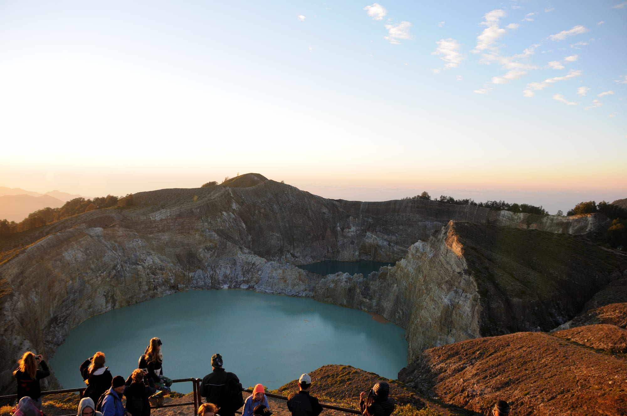 Two crater lakes of different colours separated by a rocky ridge, seen from a viewpoint