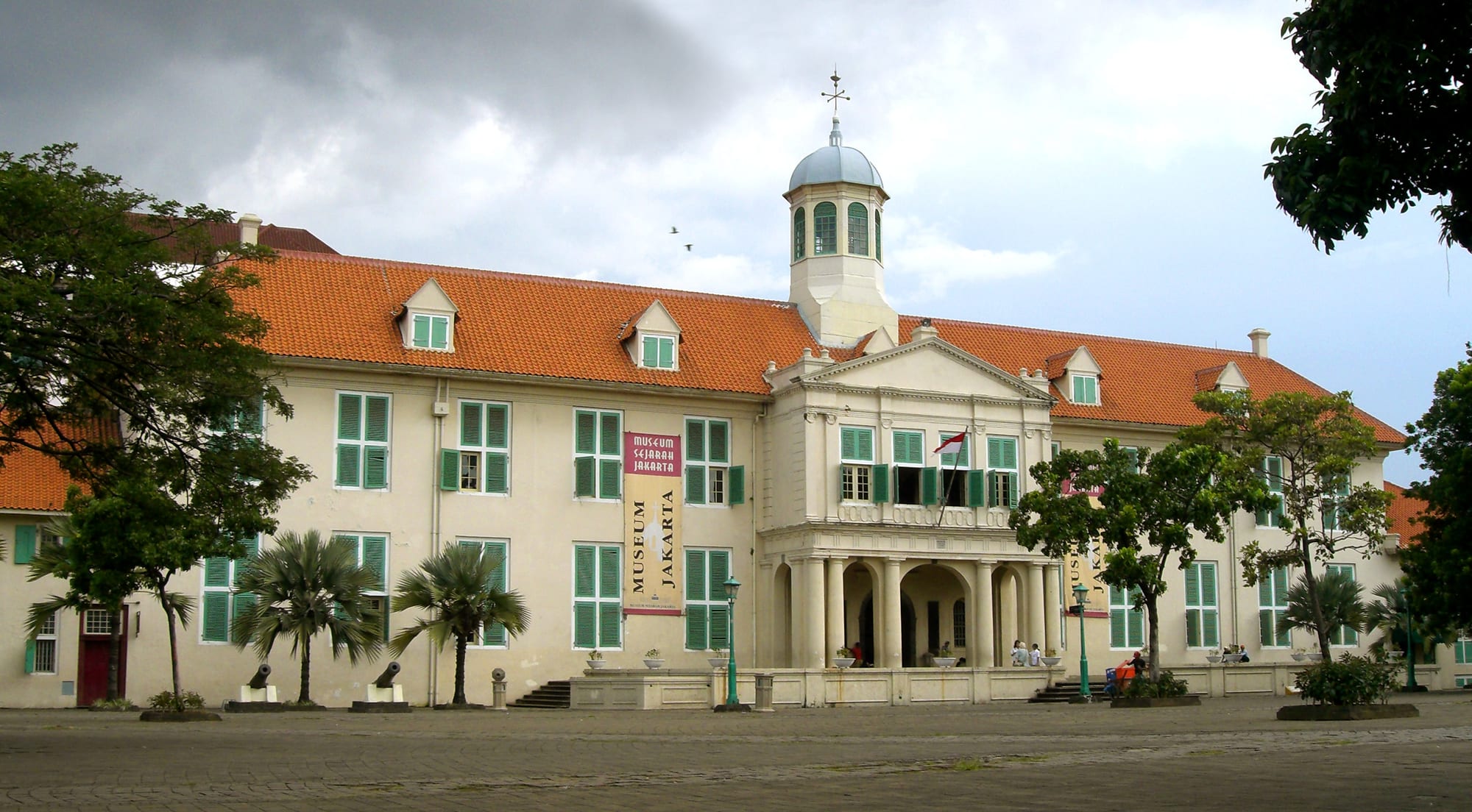 A white Dutch colonial town hall with shuttered windows and a bell tower in old Jakarta