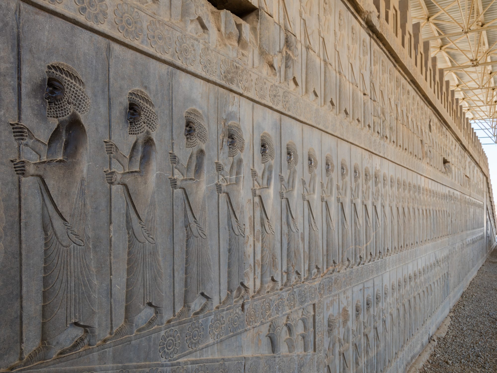 Tall fluted stone columns and a carved doorway standing on a raised terrace in a dry plain