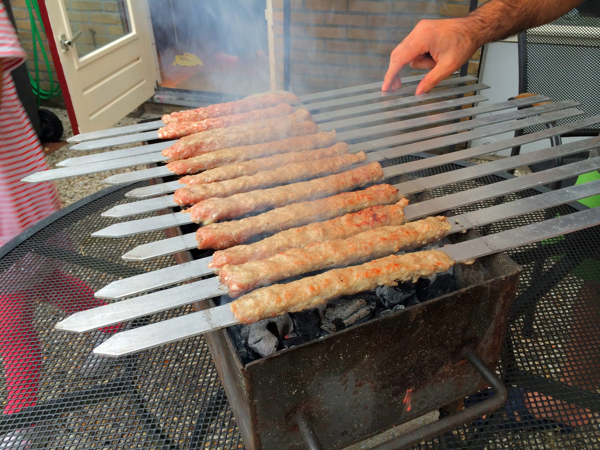 Skewers of seasoned meat grilling over open flame