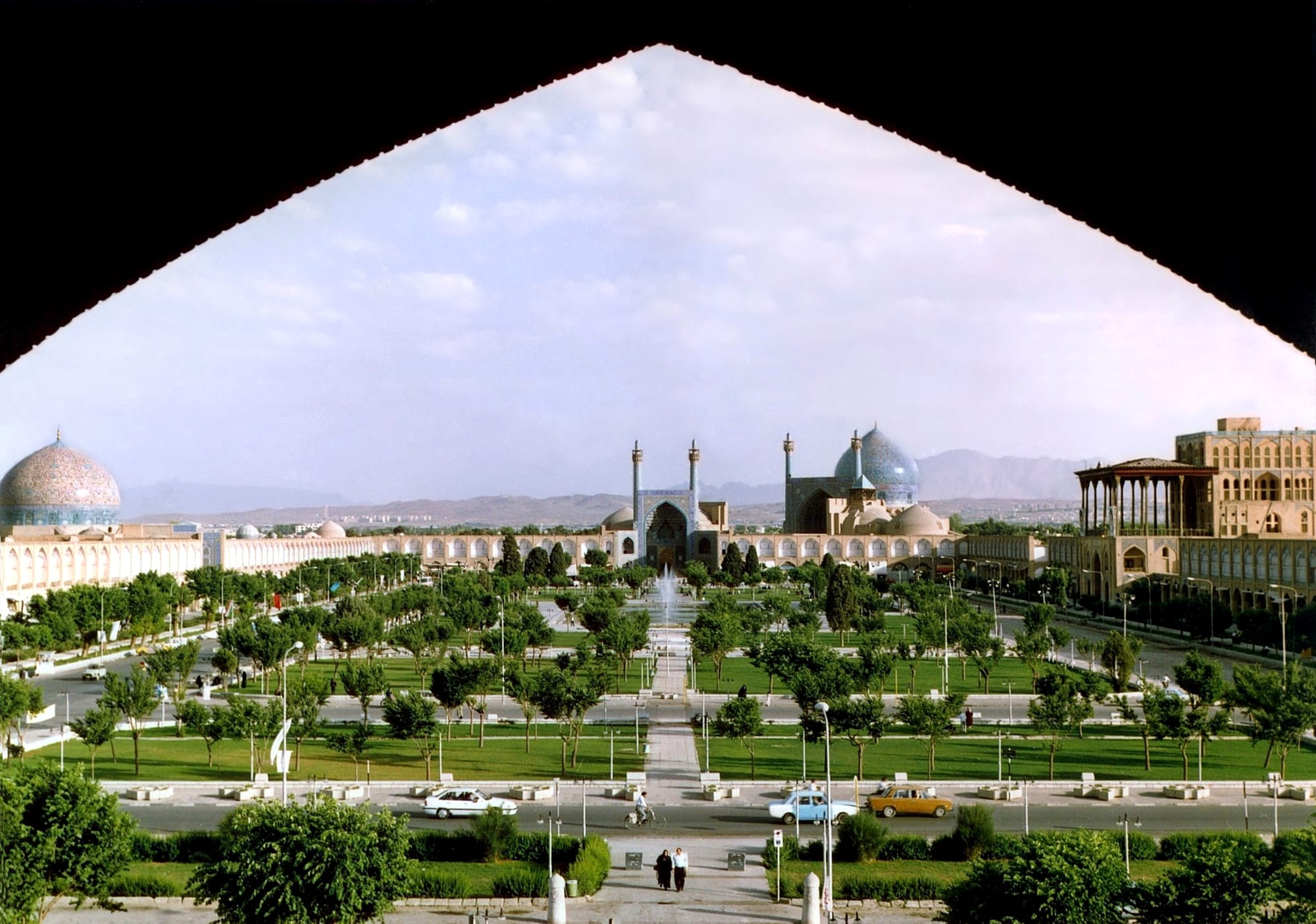 A vast rectangular plaza framed by arcades, with a great blue-tiled mosque dome at one end
