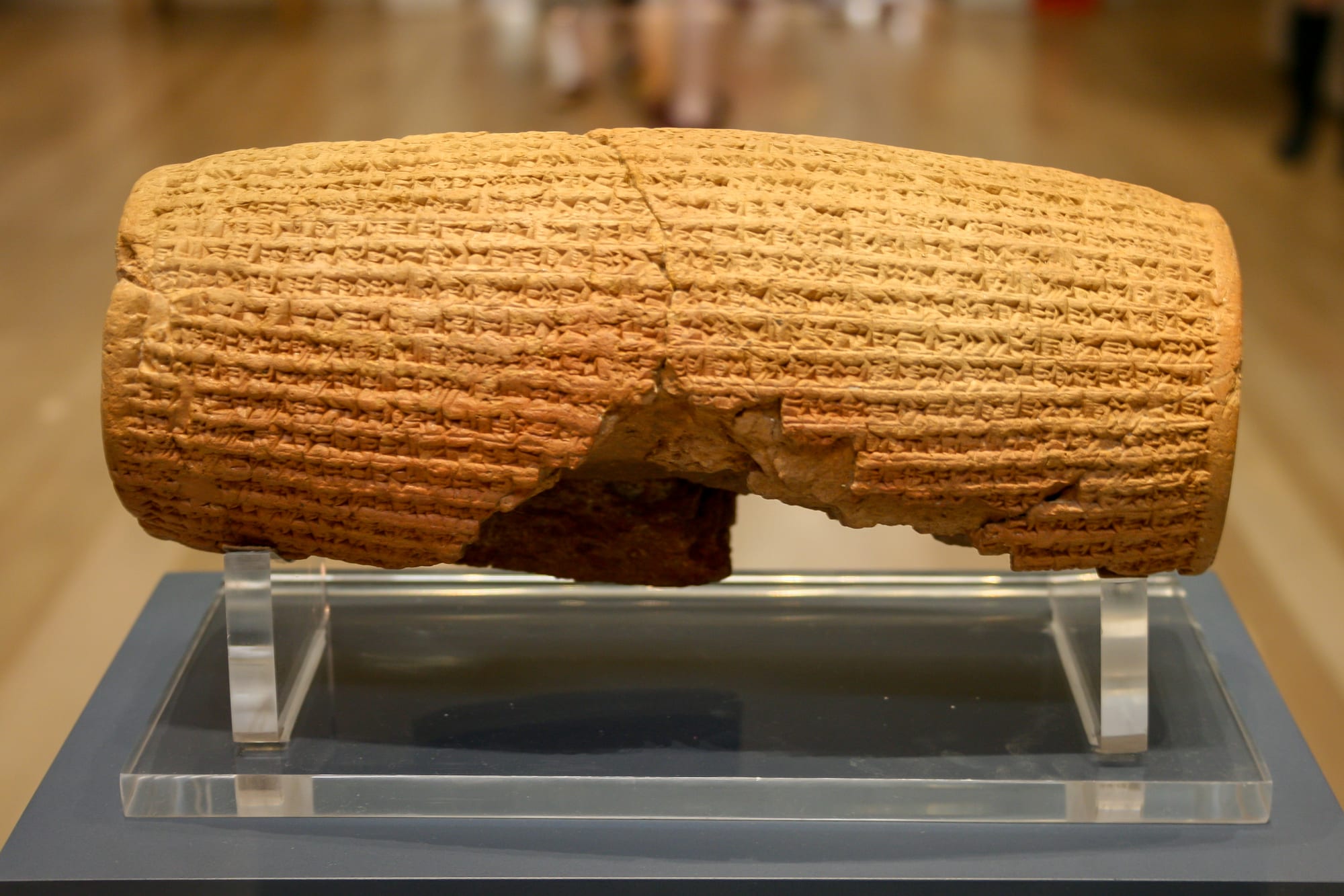 A barrel-shaped clay cylinder covered in cuneiform inscription